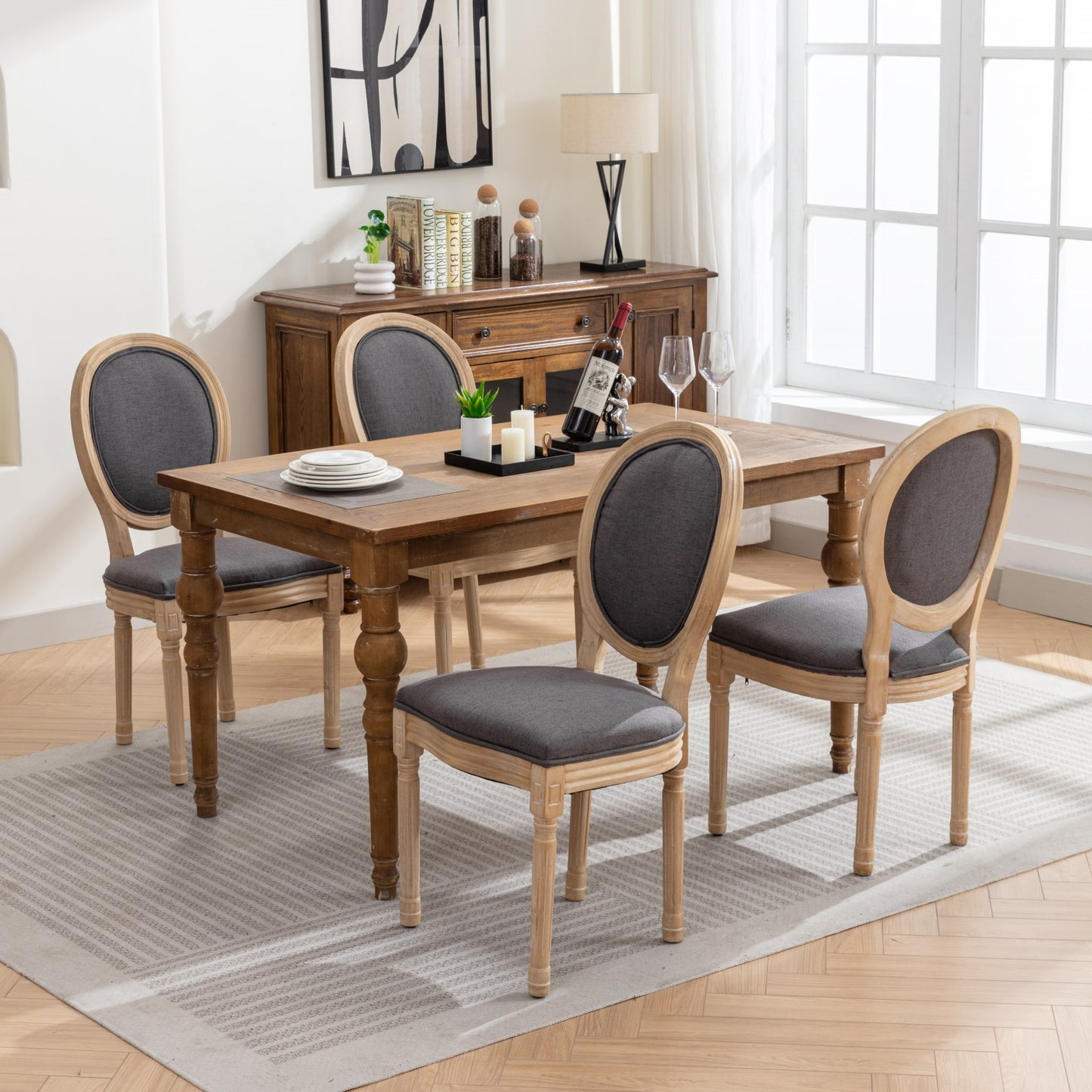 Set of four upholstered dining chairs with grey fabric seats and distressed wood frames