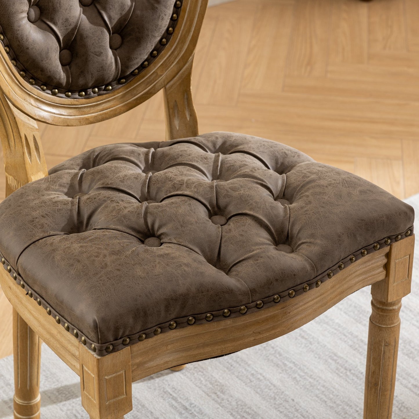 Brown tufted dining chair with distressed faux leather upholstery and nailhead trim