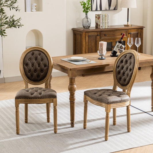 Brown tufted oval back dining chairs with distressed leatherette seats and wood frames