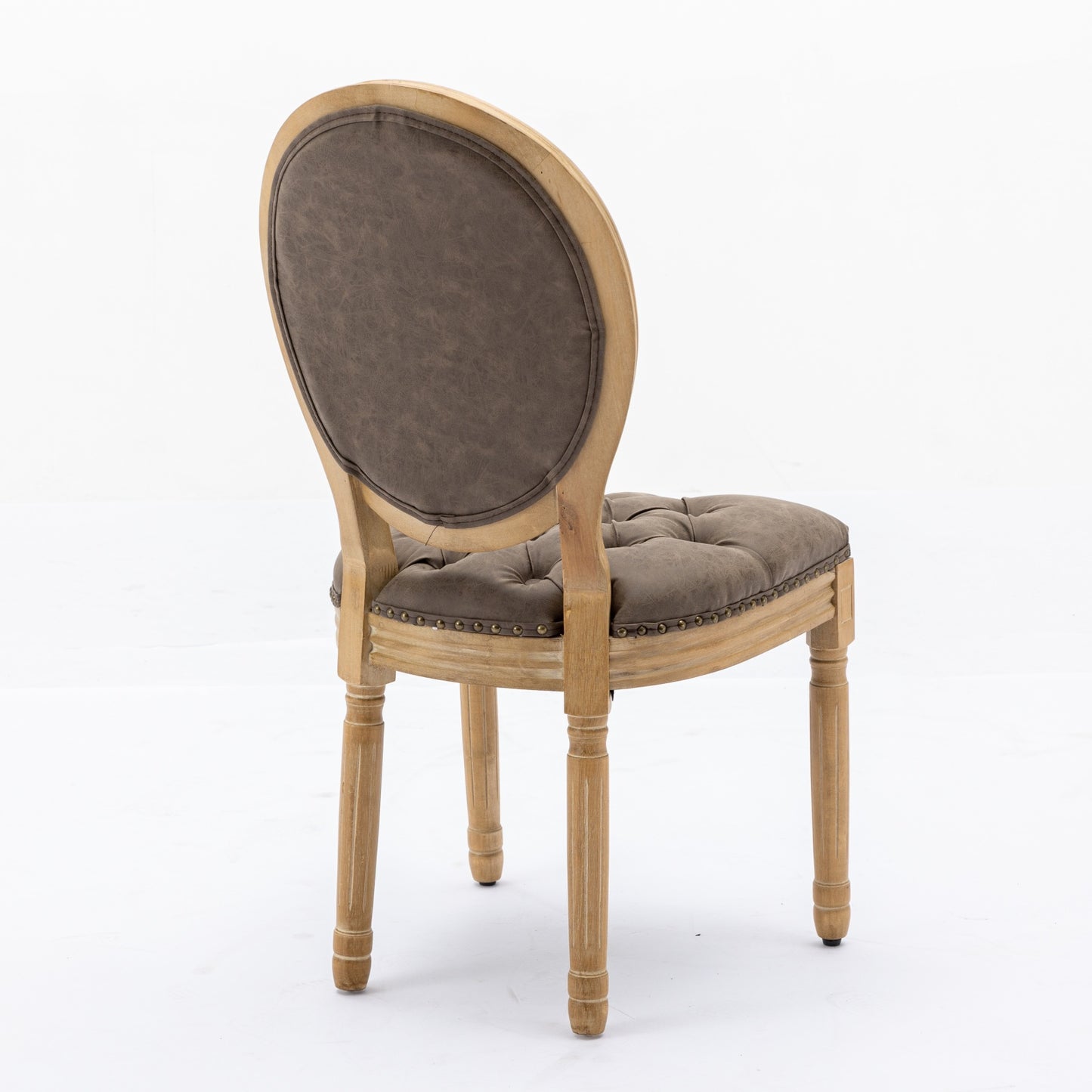 A brown upholstered tufted accent chair with distressed wooden legs and nailhead trim