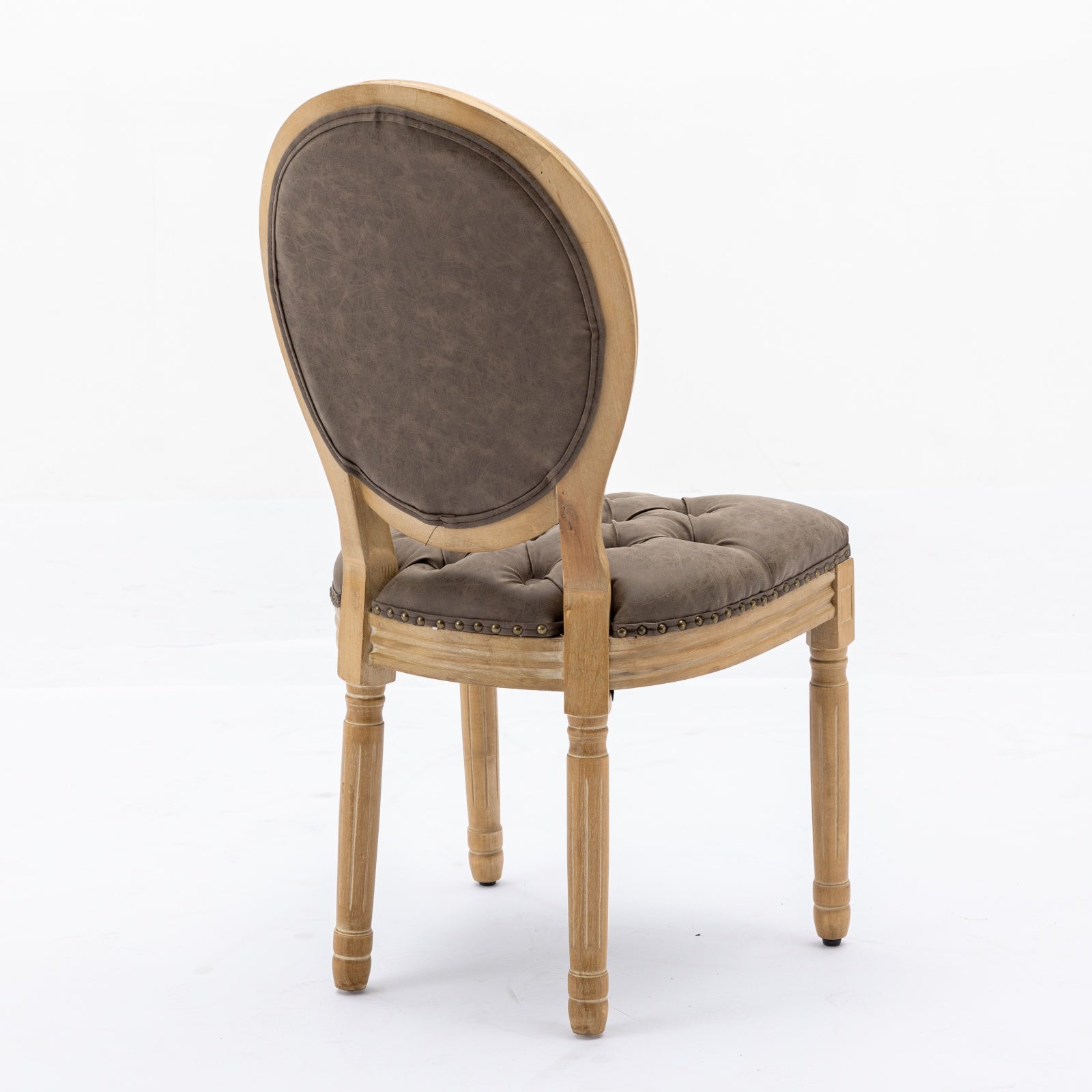 A brown upholstered tufted accent chair with distressed wooden legs and nailhead trim