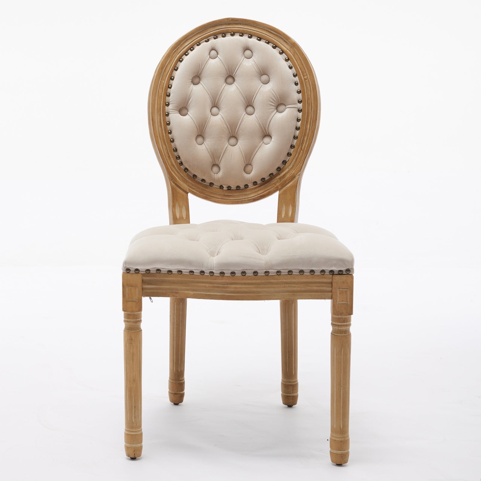 Tufted cream velvet dining chair with light wood frame and brass nailhead trim