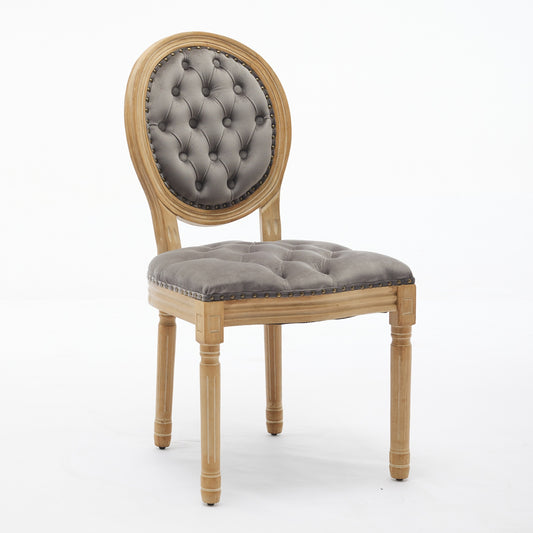 Grey tufted velvet accent chair with carved wooden frame and brass nailhead trim