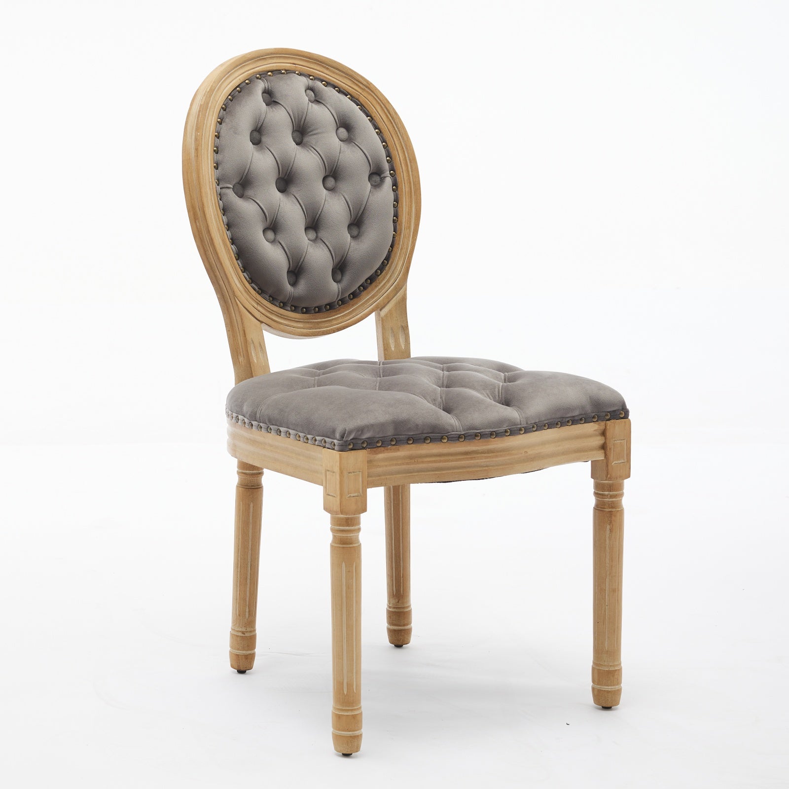 Tufted grey velvet accent chair with carved wooden legs and nailhead trim
