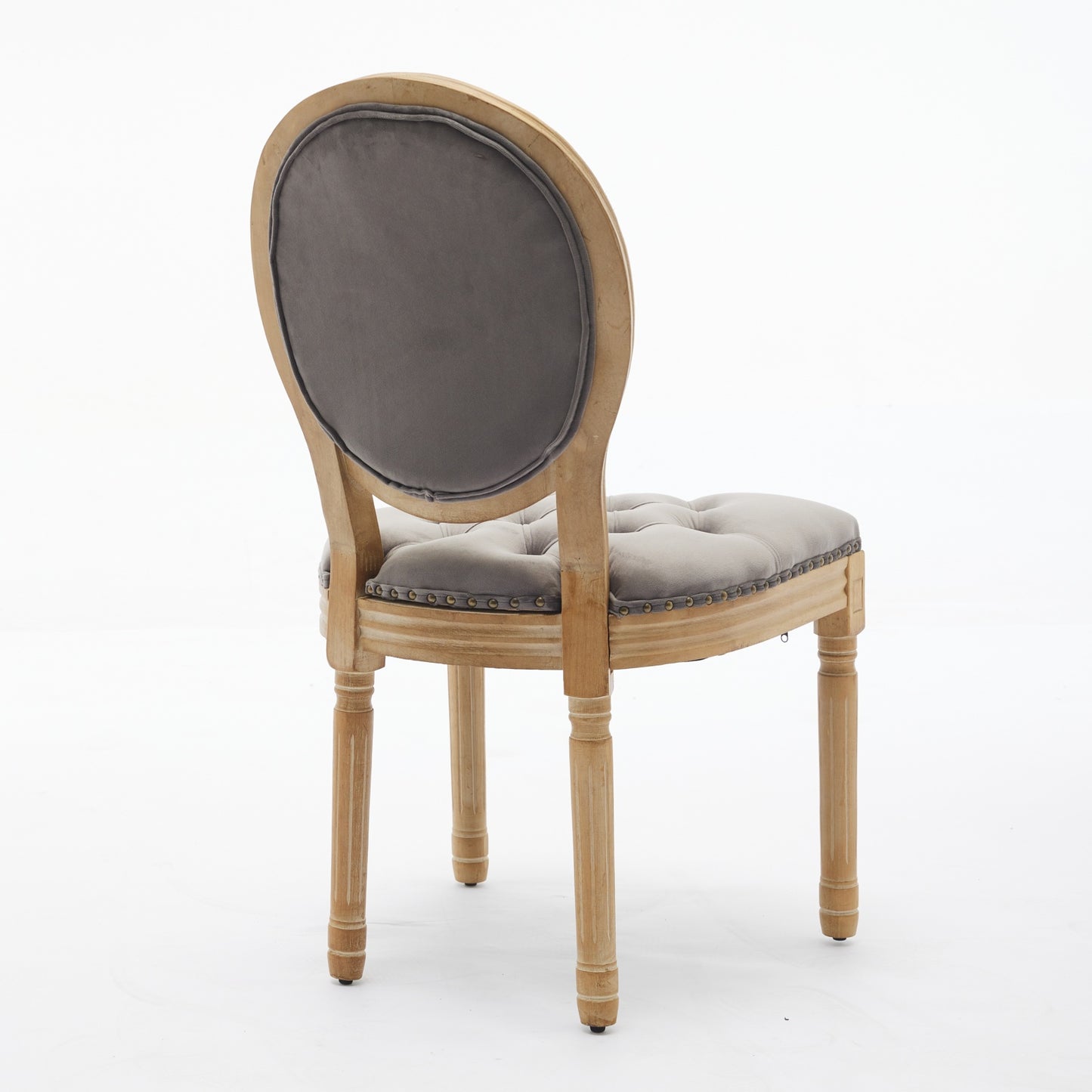 Grey velvet dining chair with tufted seat and carved wooden legs