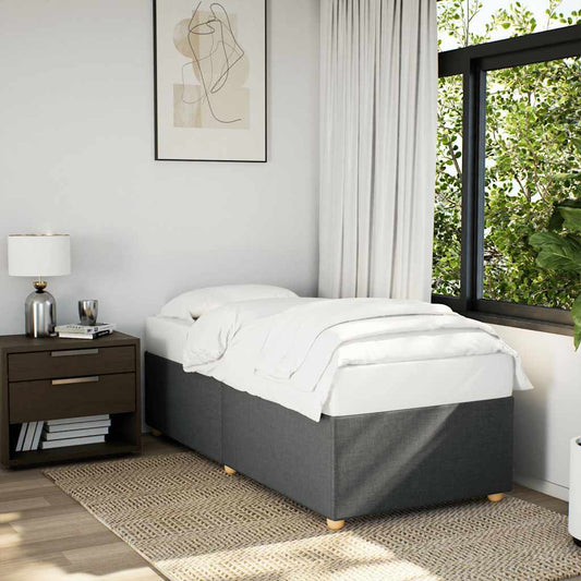 Gray upholstered divan bed with white bedding