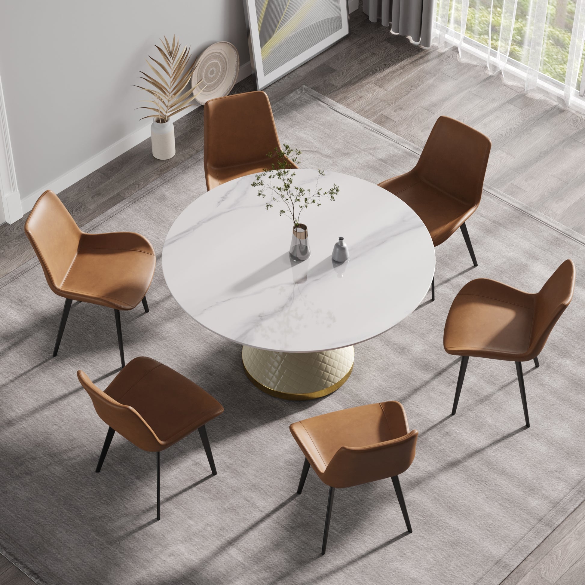 Round marble top dining table with tufted pedestal base and six caramel leather chairs