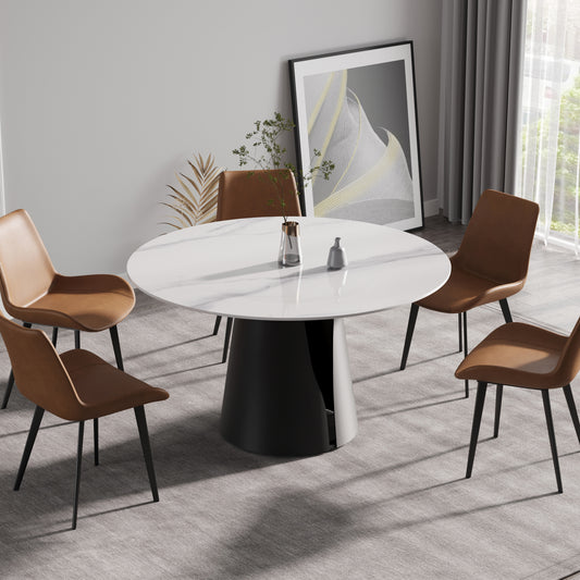 Round marble dining table with black pedestal base and four brown leather chairs