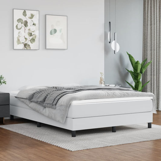 White upholstered bed frame with black legs and a grey throw blanket