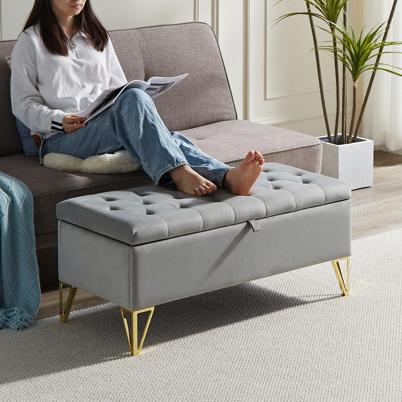 Gray velvet storage ottoman with tufted top and gold legs