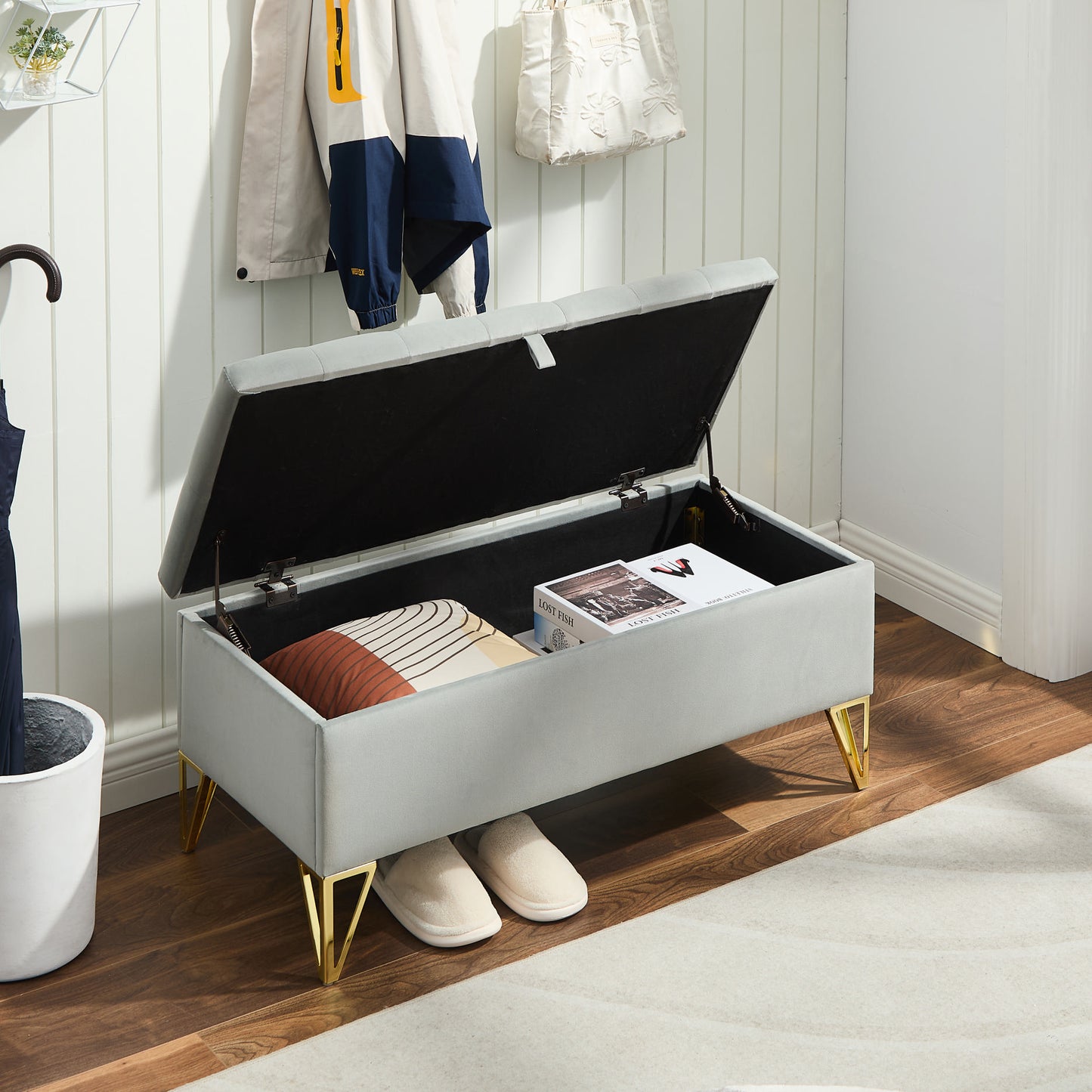 Gray velvet storage ottoman with tufted lid and gold legs