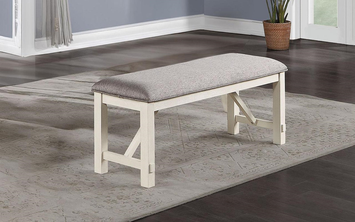 Gray upholstered dining bench with distressed white wood frame