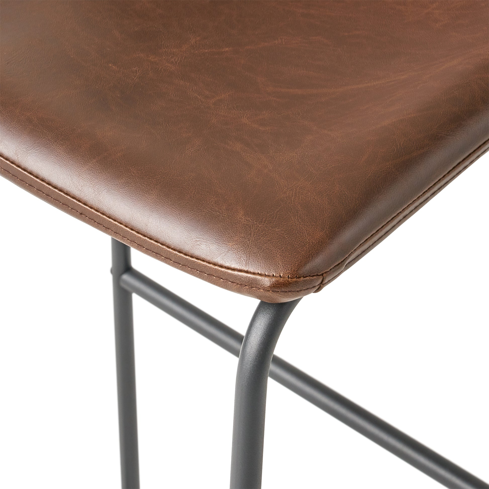 Closeup of distressed brown faux leather seat on a bar stool