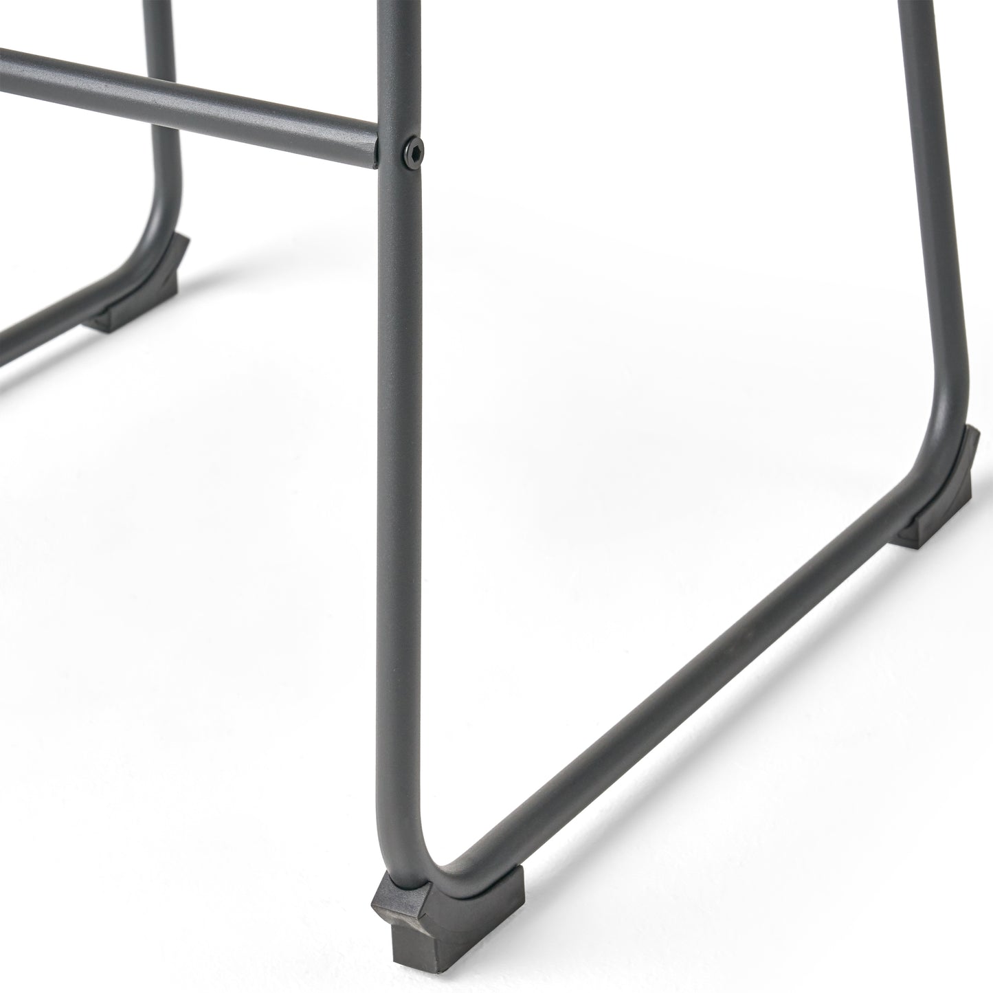 Closeup of dark gray metal chair legs with black protective feet