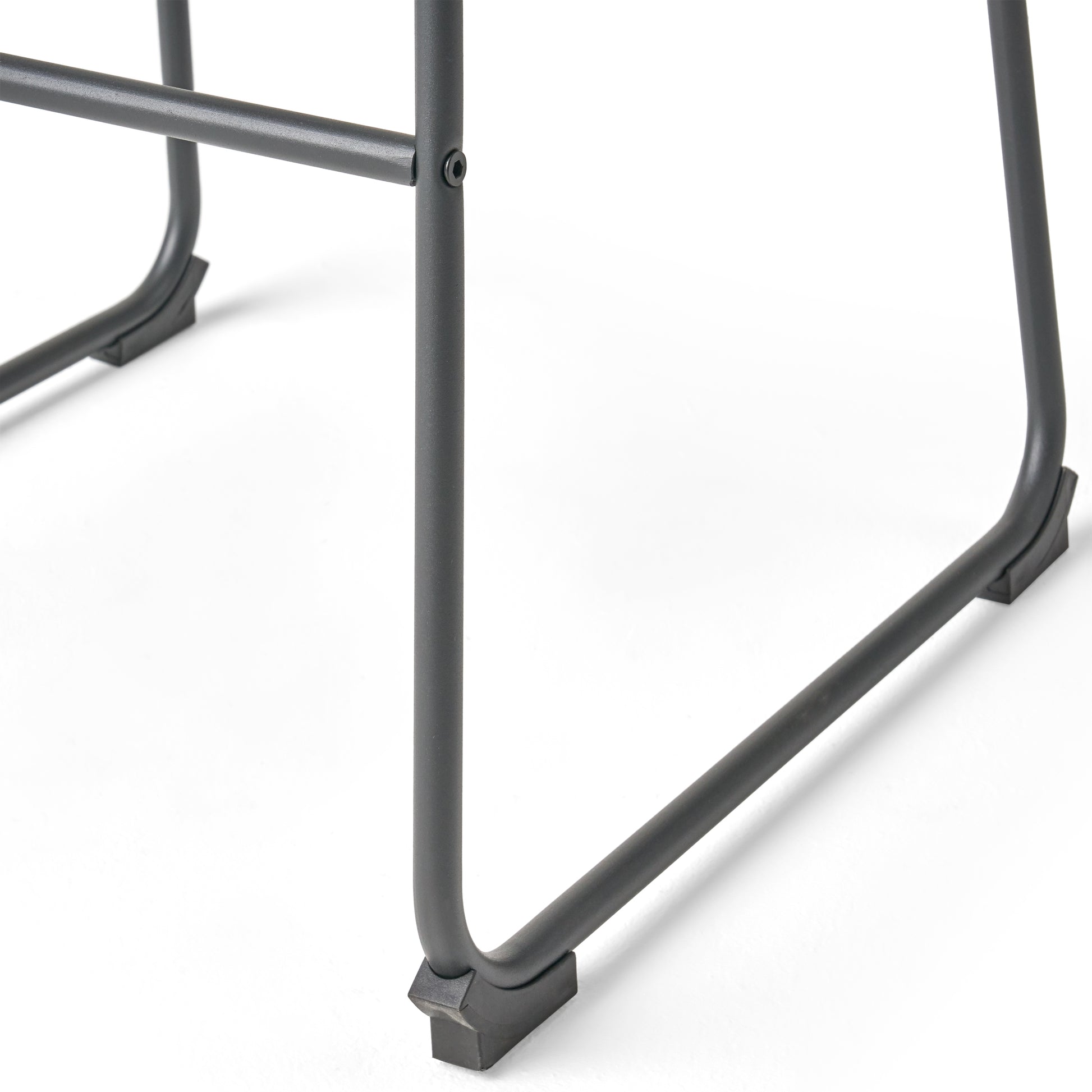 Closeup of dark gray metal chair legs with black protective feet