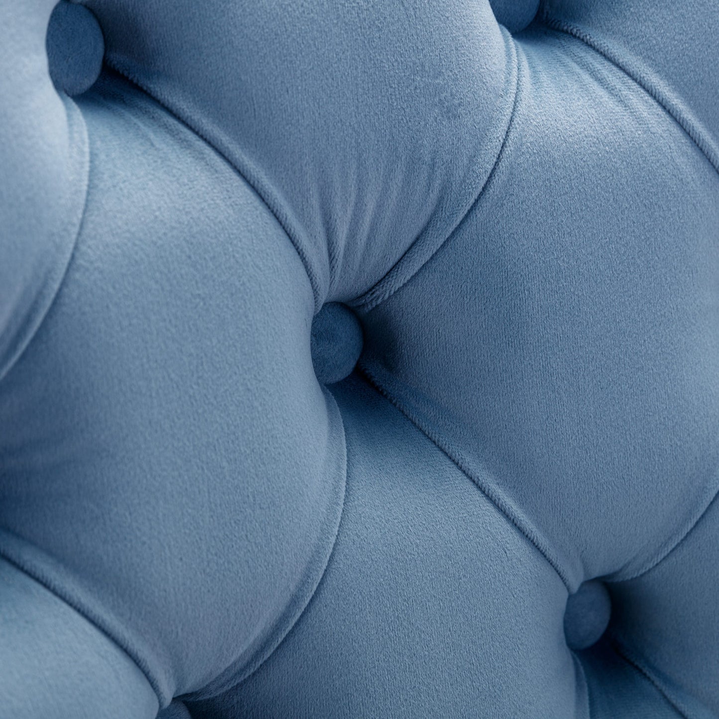 Closeup of dusty blue velvet tufted upholstery with deep diamond stitching