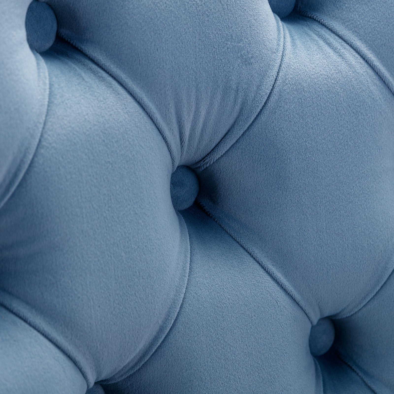 Closeup of dusty blue velvet tufted upholstery with deep diamond stitching