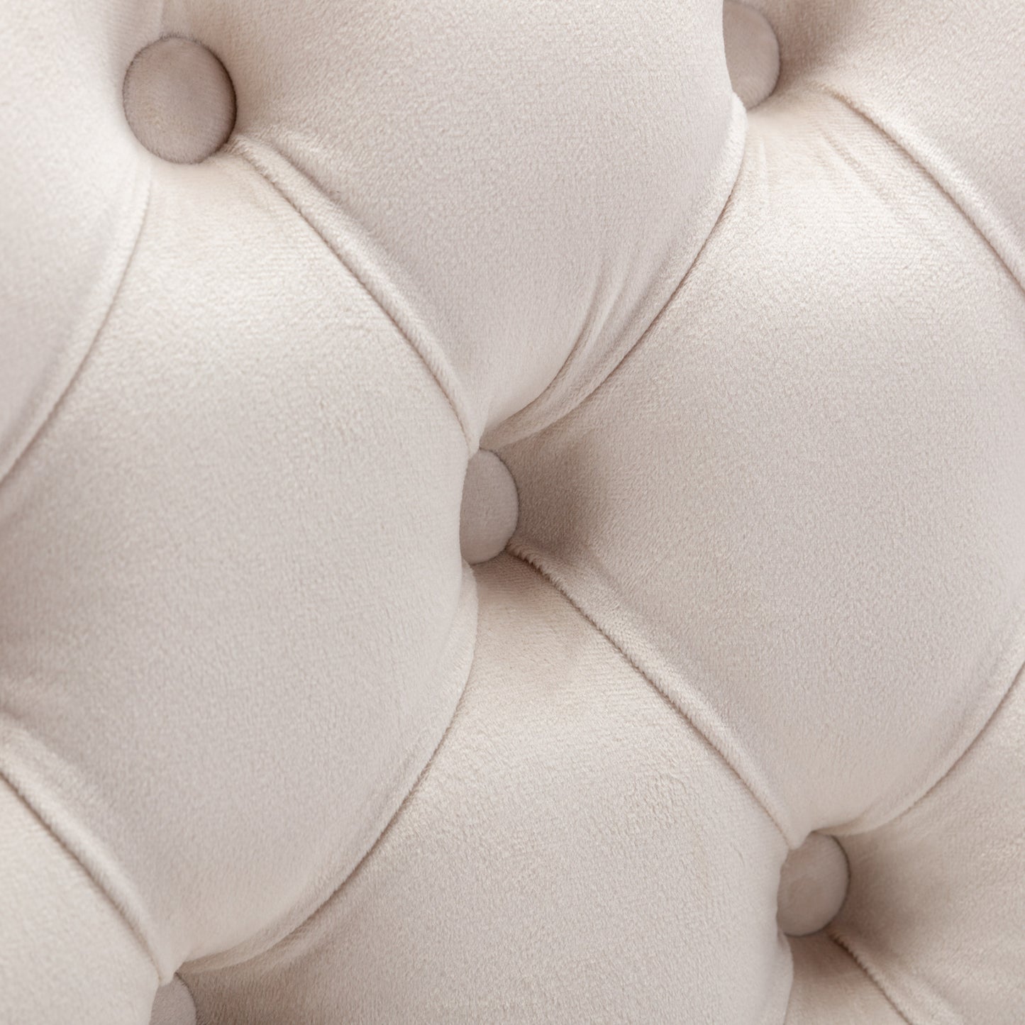 Cream velvet tufted sofa fabric detail with button accents