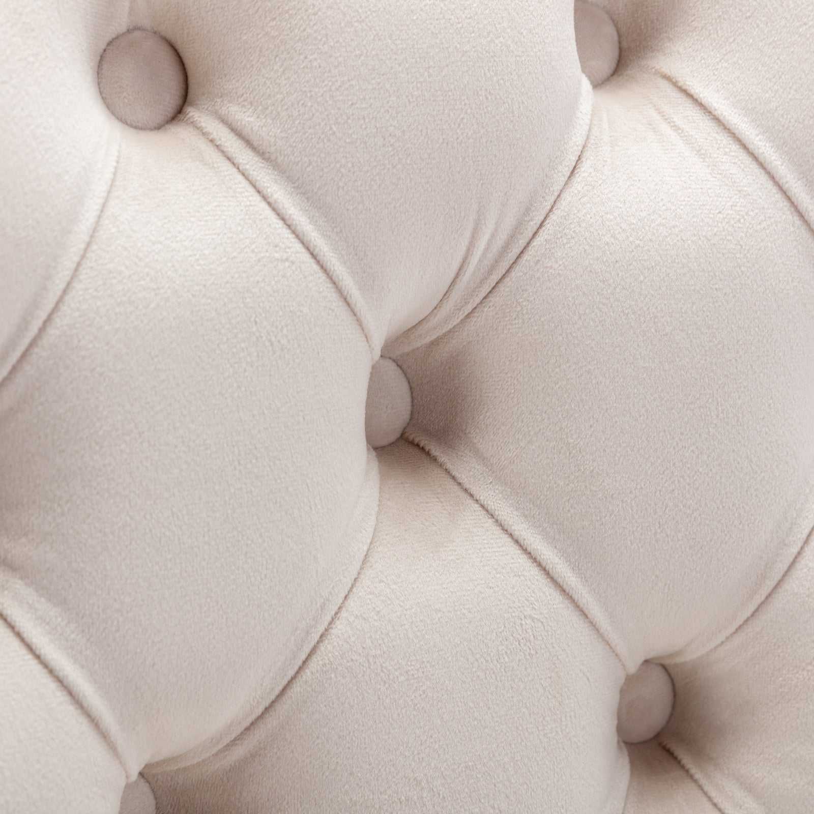 Cream velvet tufted sofa fabric detail with button accents