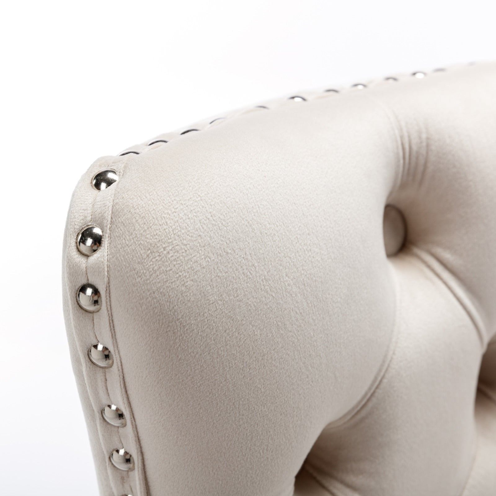Cream velvet armchair detail with silver nailhead trim and button tufting