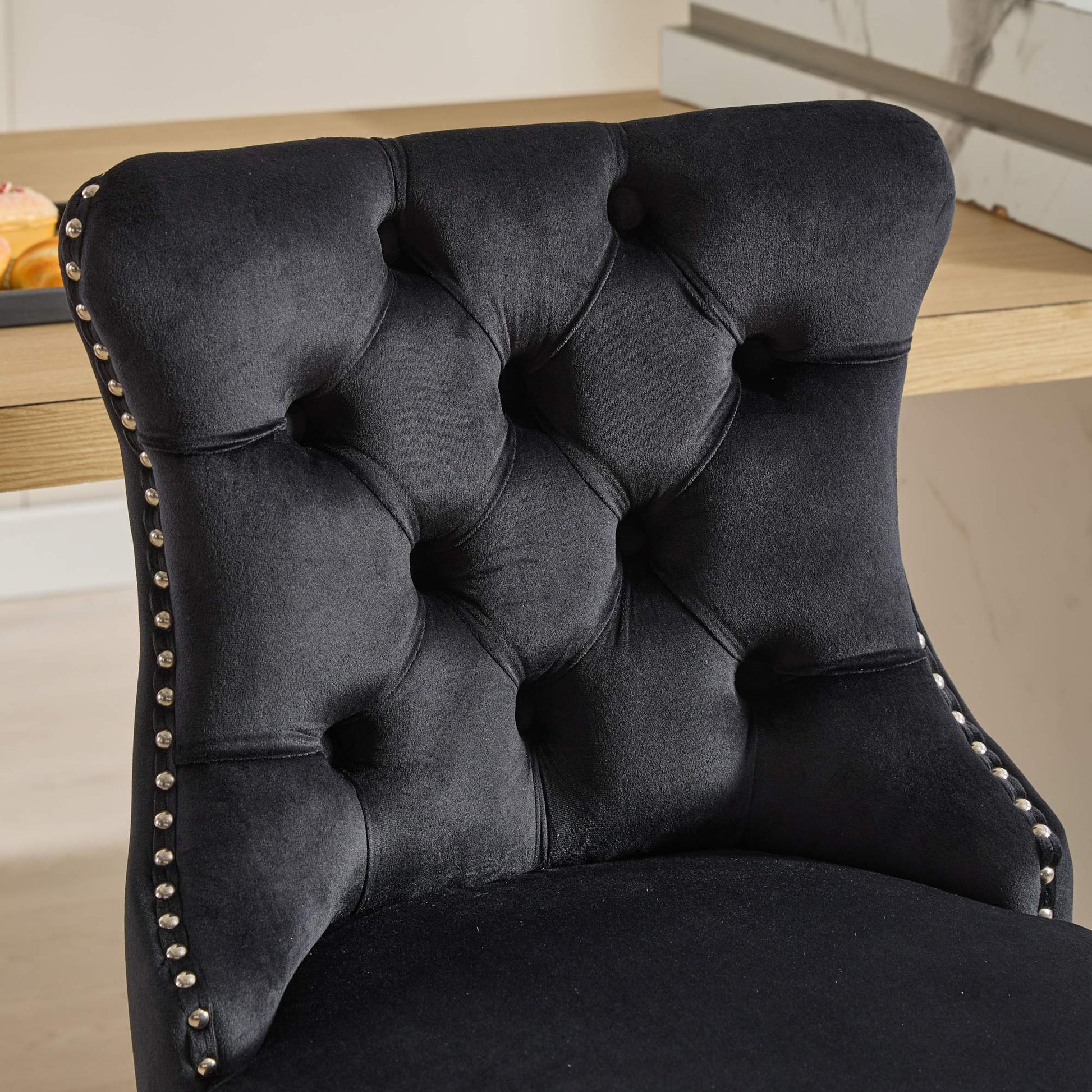 Black velvet bar stool with diamond tufting and silver nailhead trim