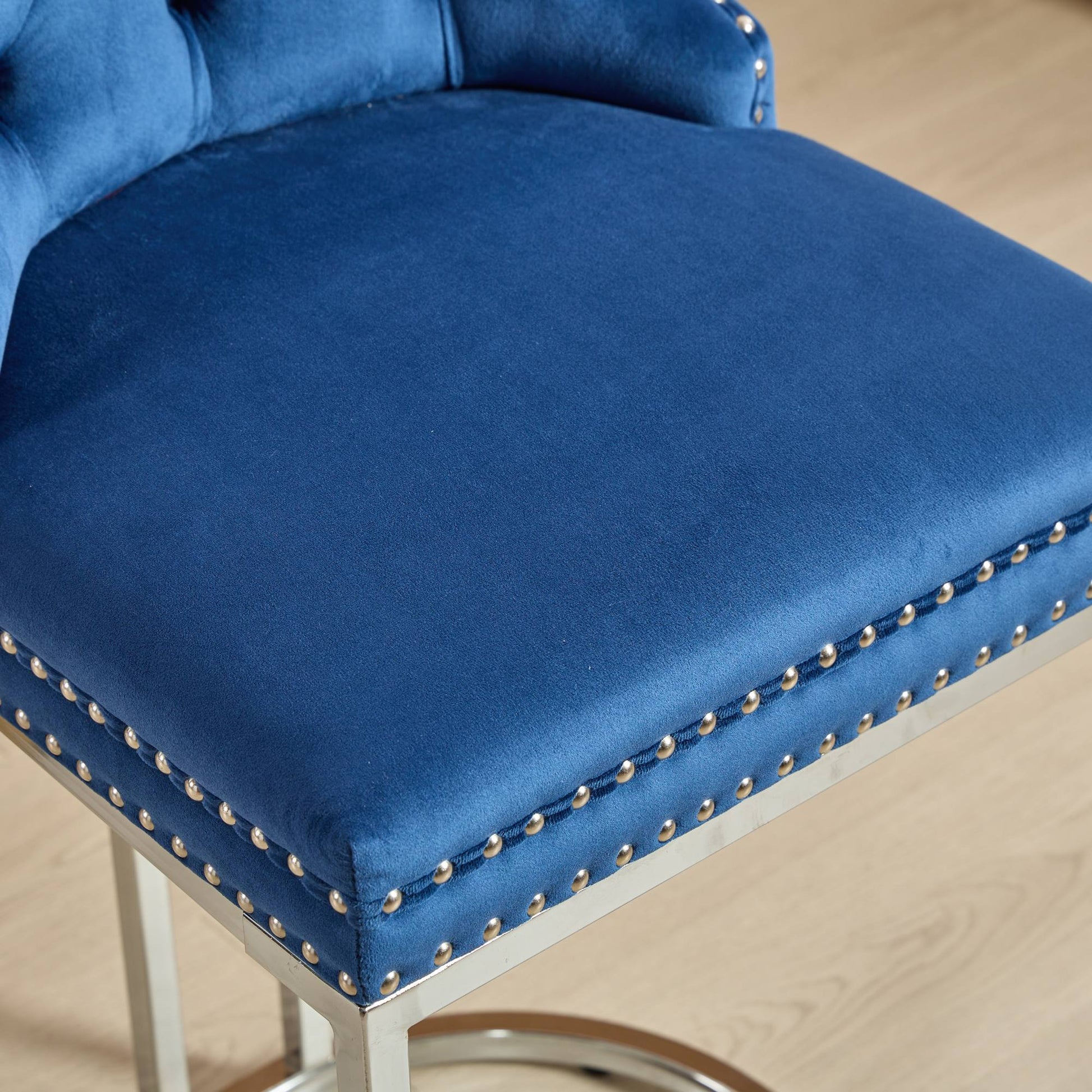 Closeup of plush navy velvet bar stool seat with silver nailhead trim