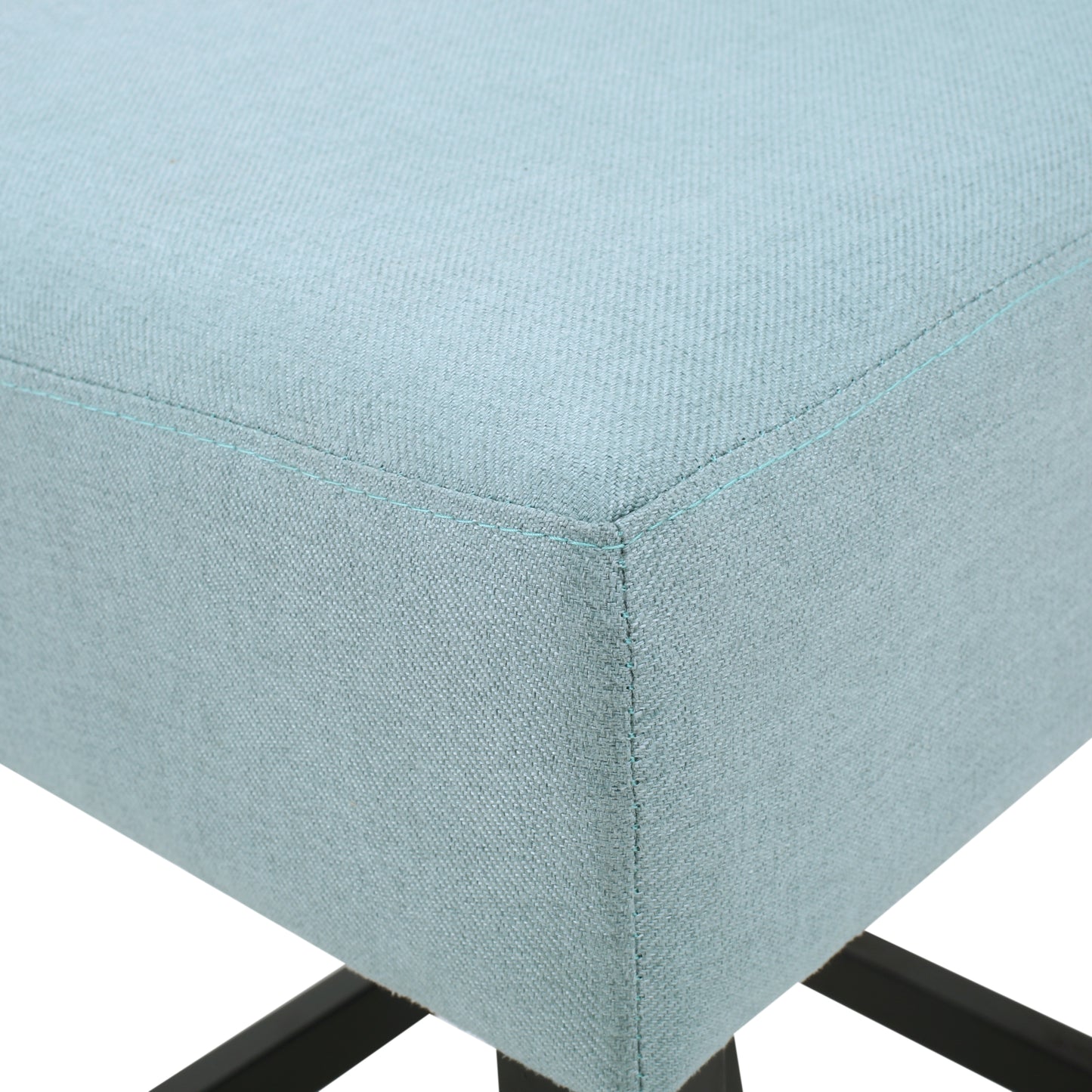 Closeup of light blue fabric ottoman with subtle stitching and black metal legs