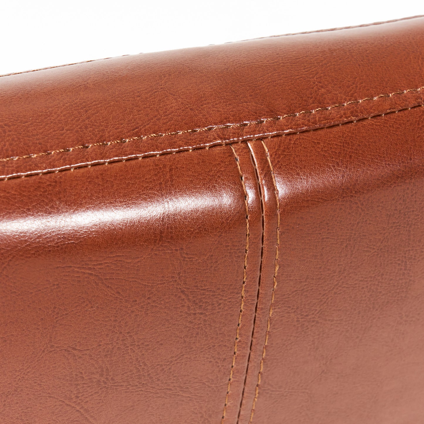 Closeup of rich brown faux leather texture with detailed stitching