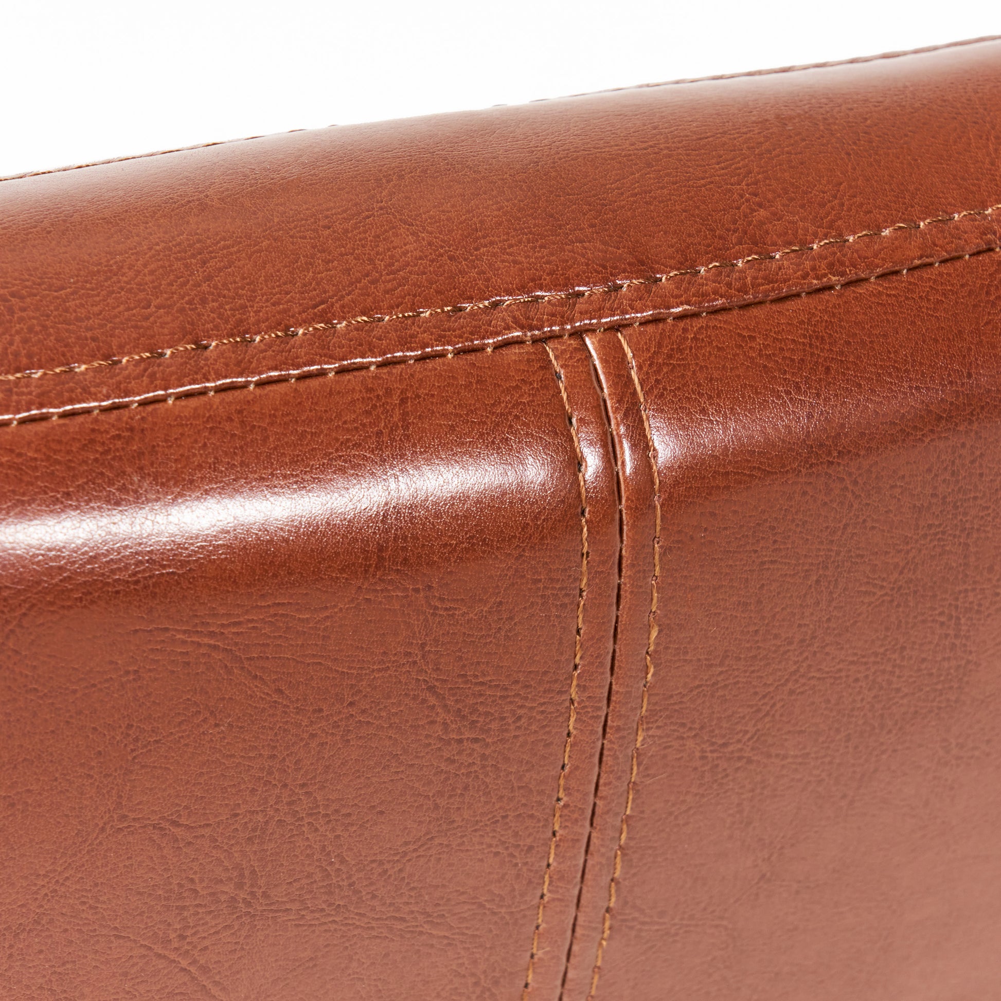 Closeup of rich brown faux leather texture with detailed stitching