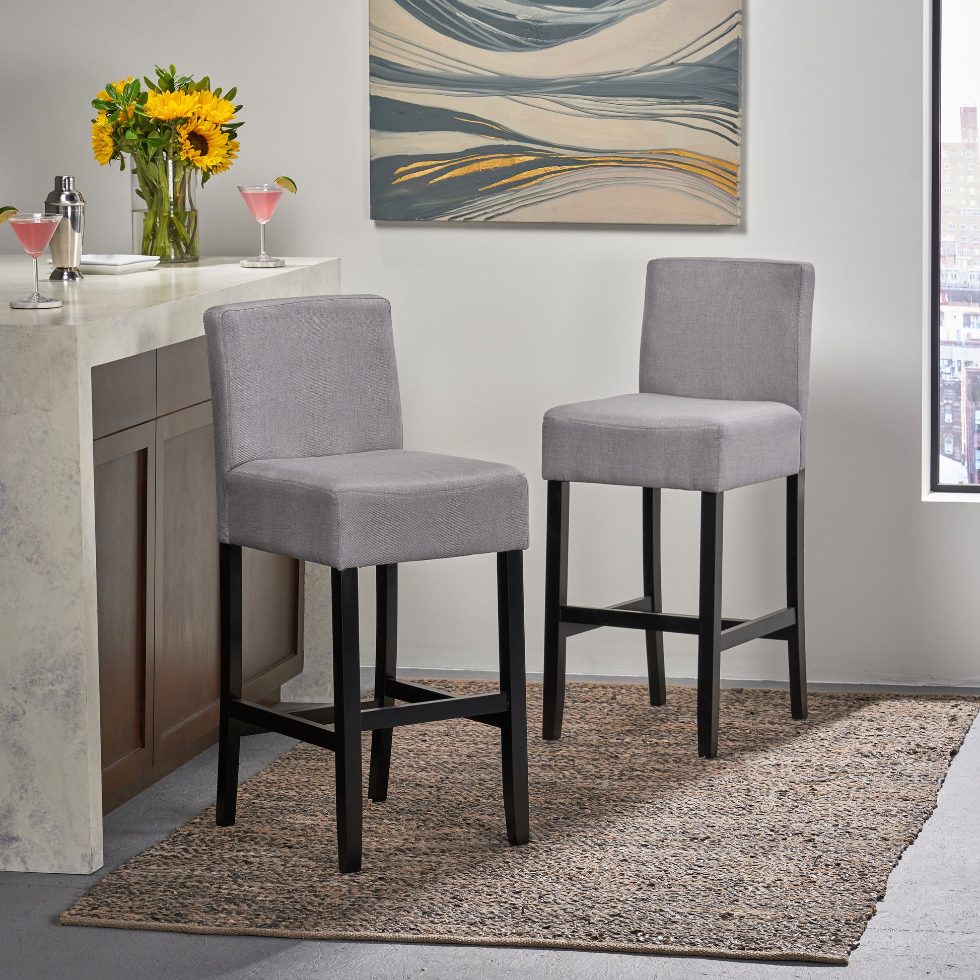 Grey upholstered bar stool with black legs