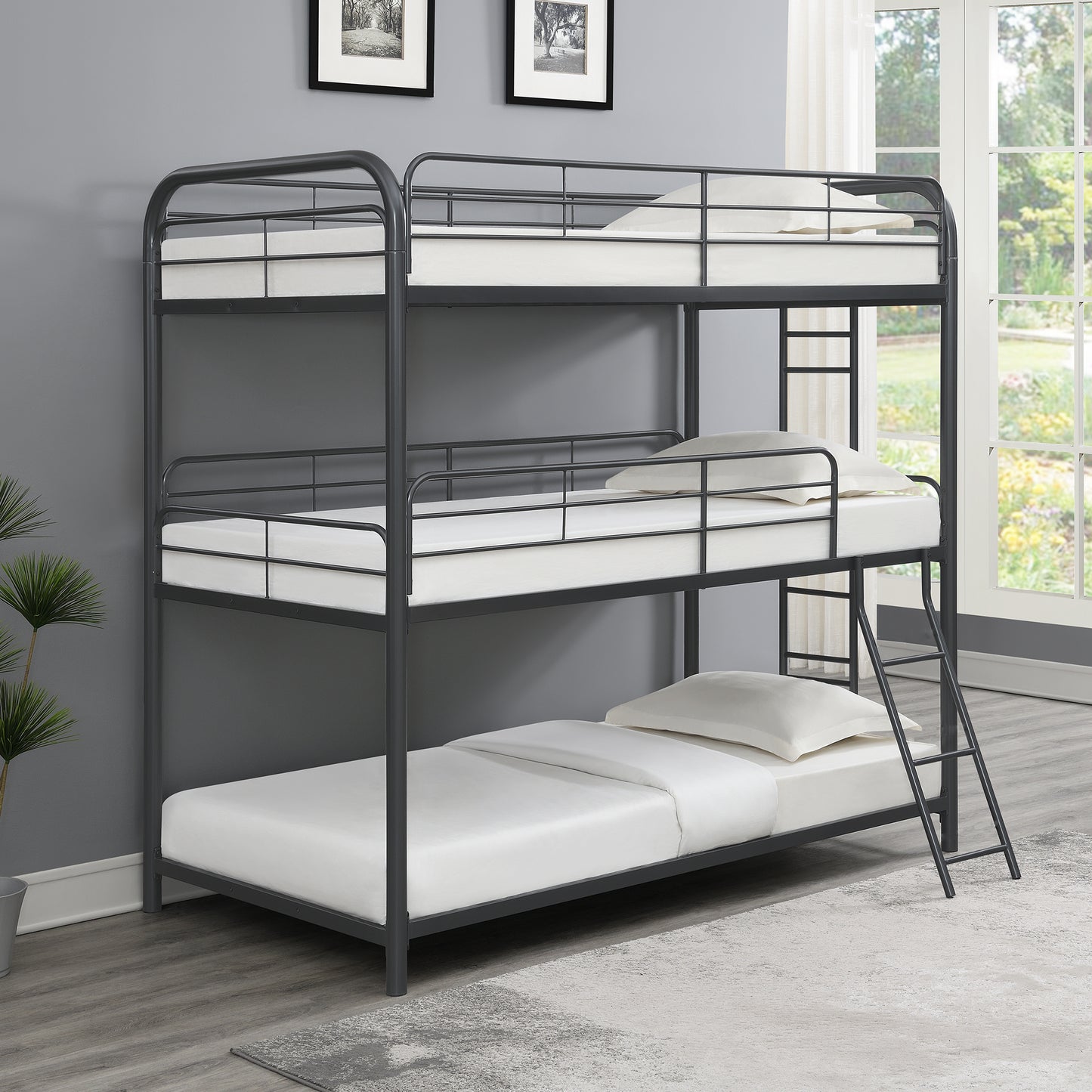 Dark gray metal triple bunk bed with white mattresses and pillows