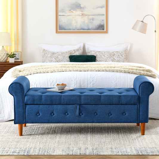 Tufted navy blue storage bench with rolled arms and wooden legs in a bedroom setting