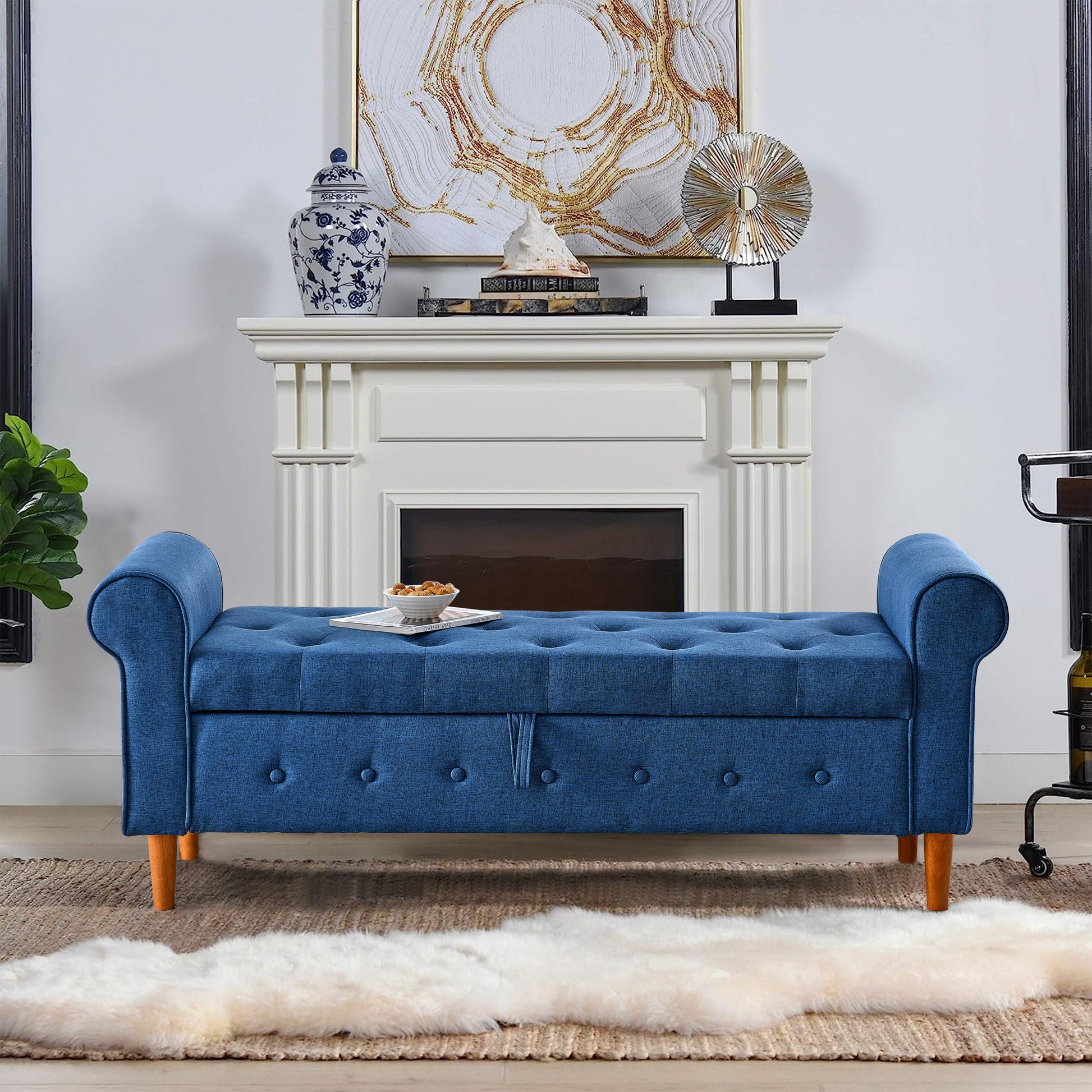 Tufted blue fabric storage bench with scroll arms and wooden legs