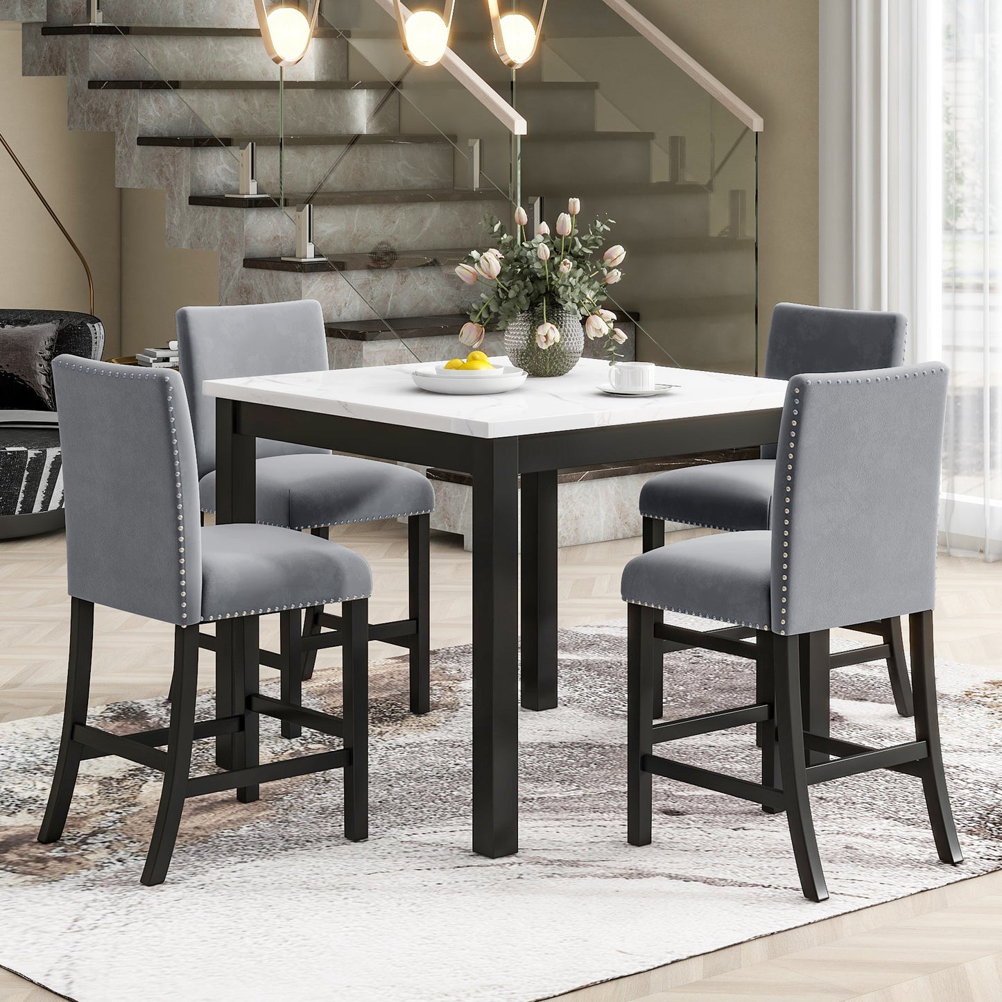Marble top counter height dining set with gray upholstered stools and nailhead trim