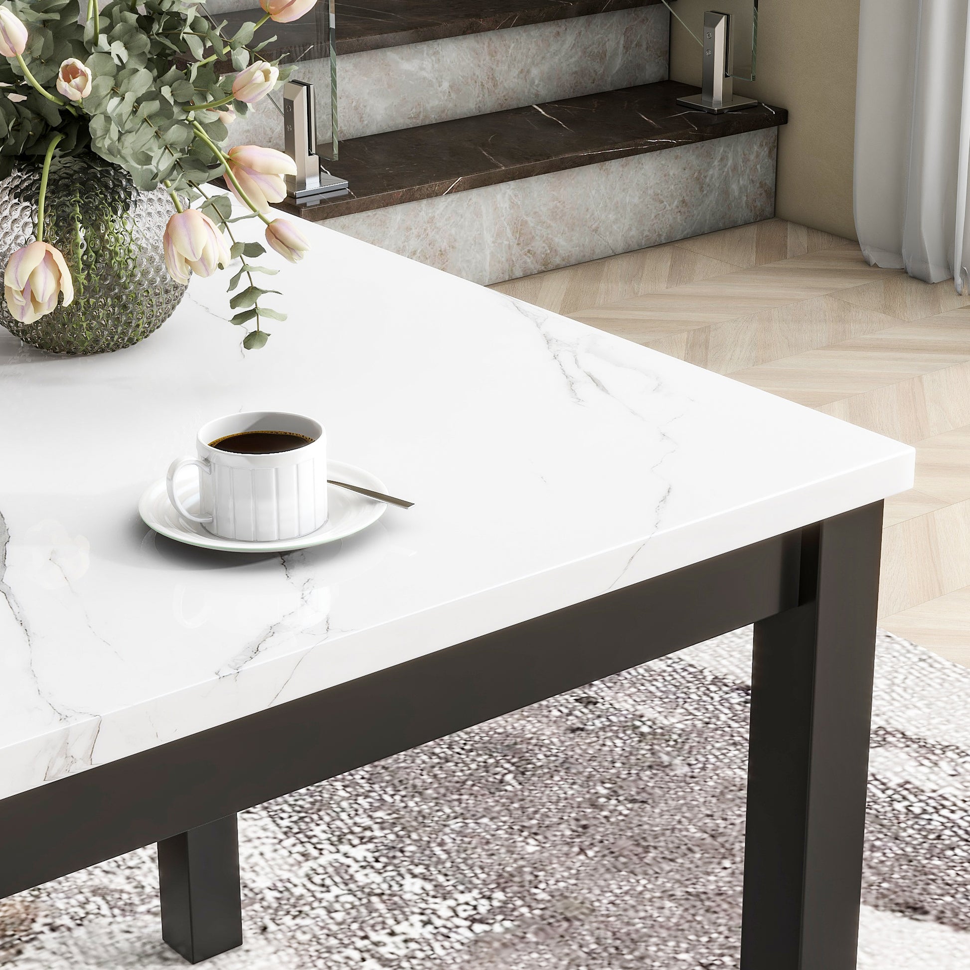 White marble top dining table with black metal legs and a cup of coffee