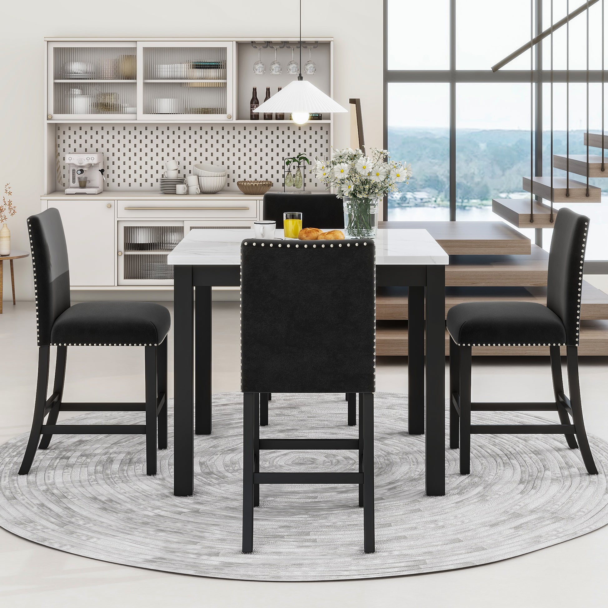 Black velvet bar stools with silver nailhead trim around a white marbletop bar table