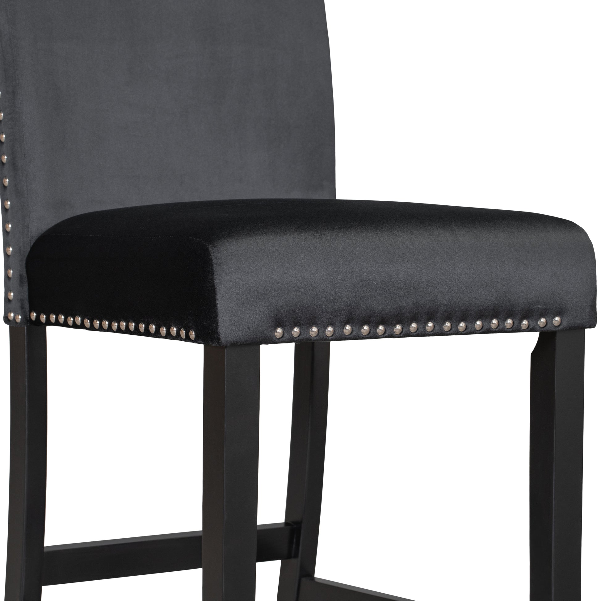 Closeup of a grey velvet tufted bar stool with silver nailhead trim and black wooden legs