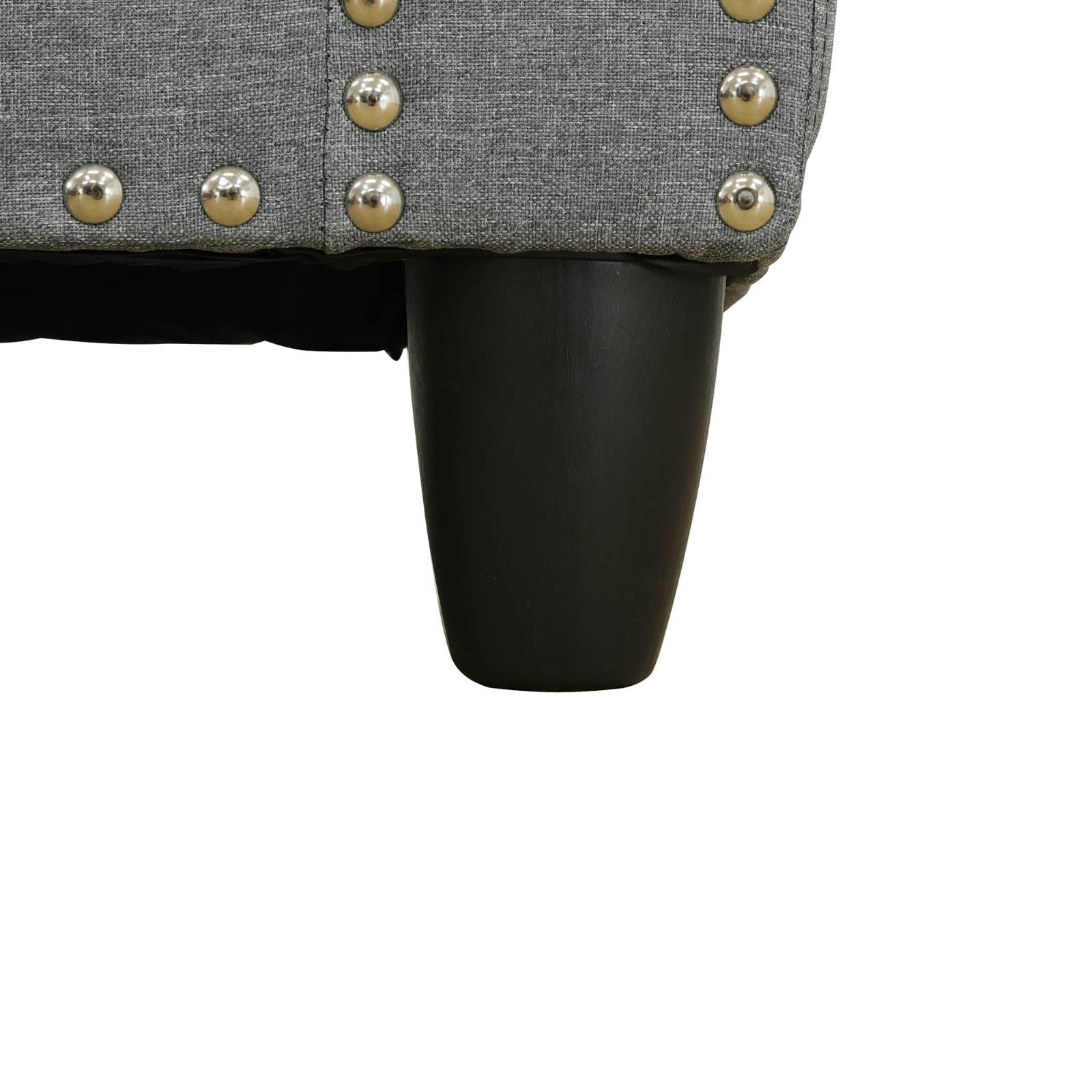 Gray upholstered chair featuring silver studs and black wooden leg
