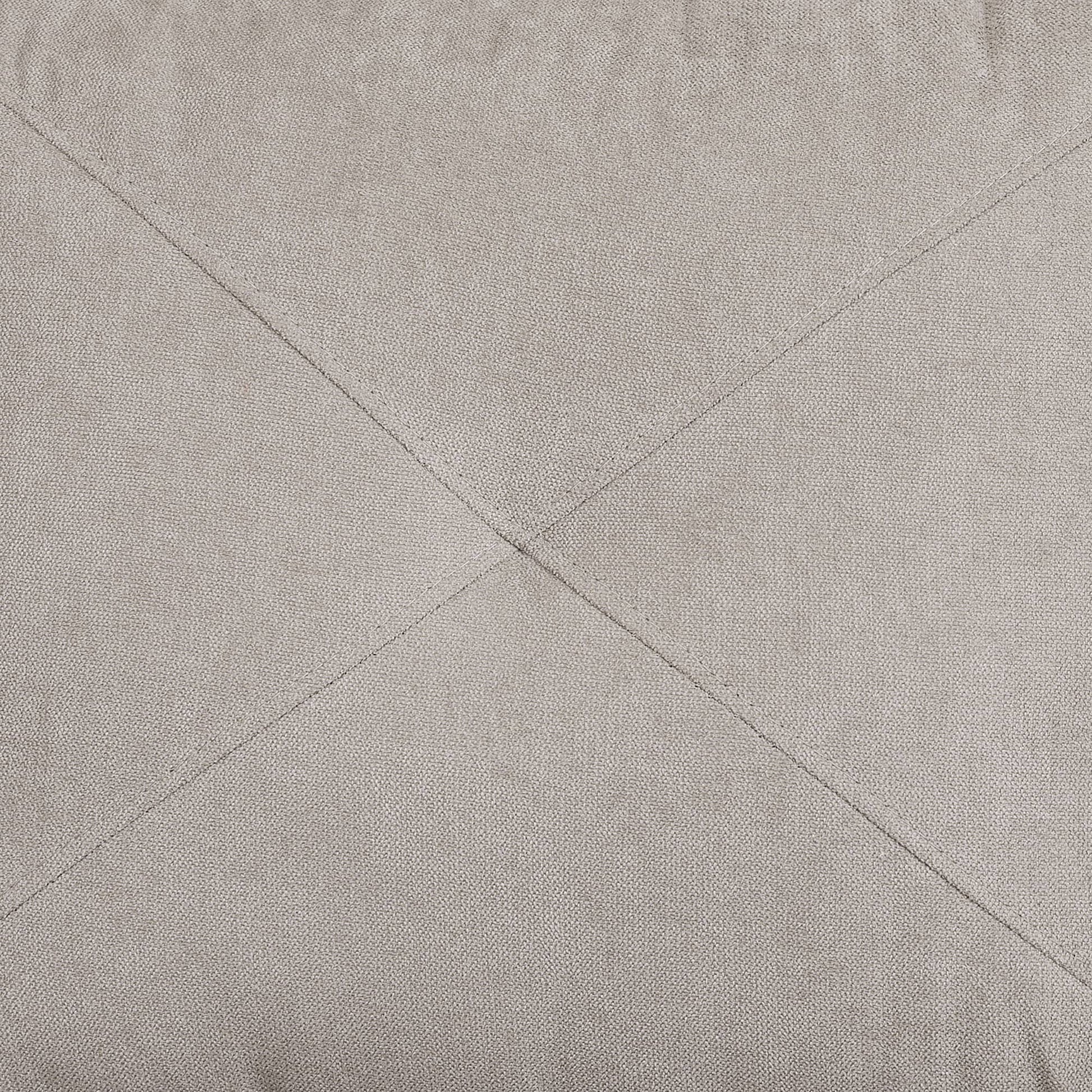 Closeup of light grey textured fabric with subtle diamond stitching