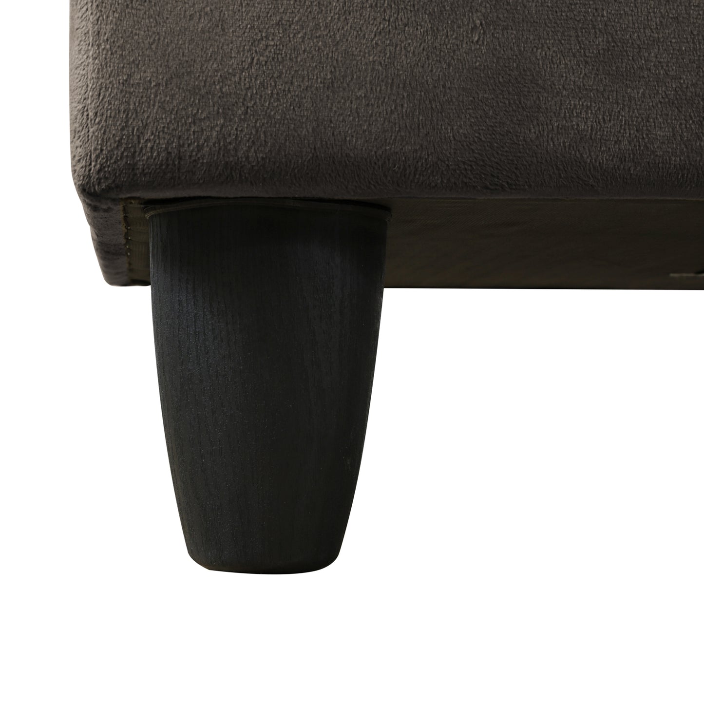 Dark grey plush sofa arm detail with tapered black wooden leg