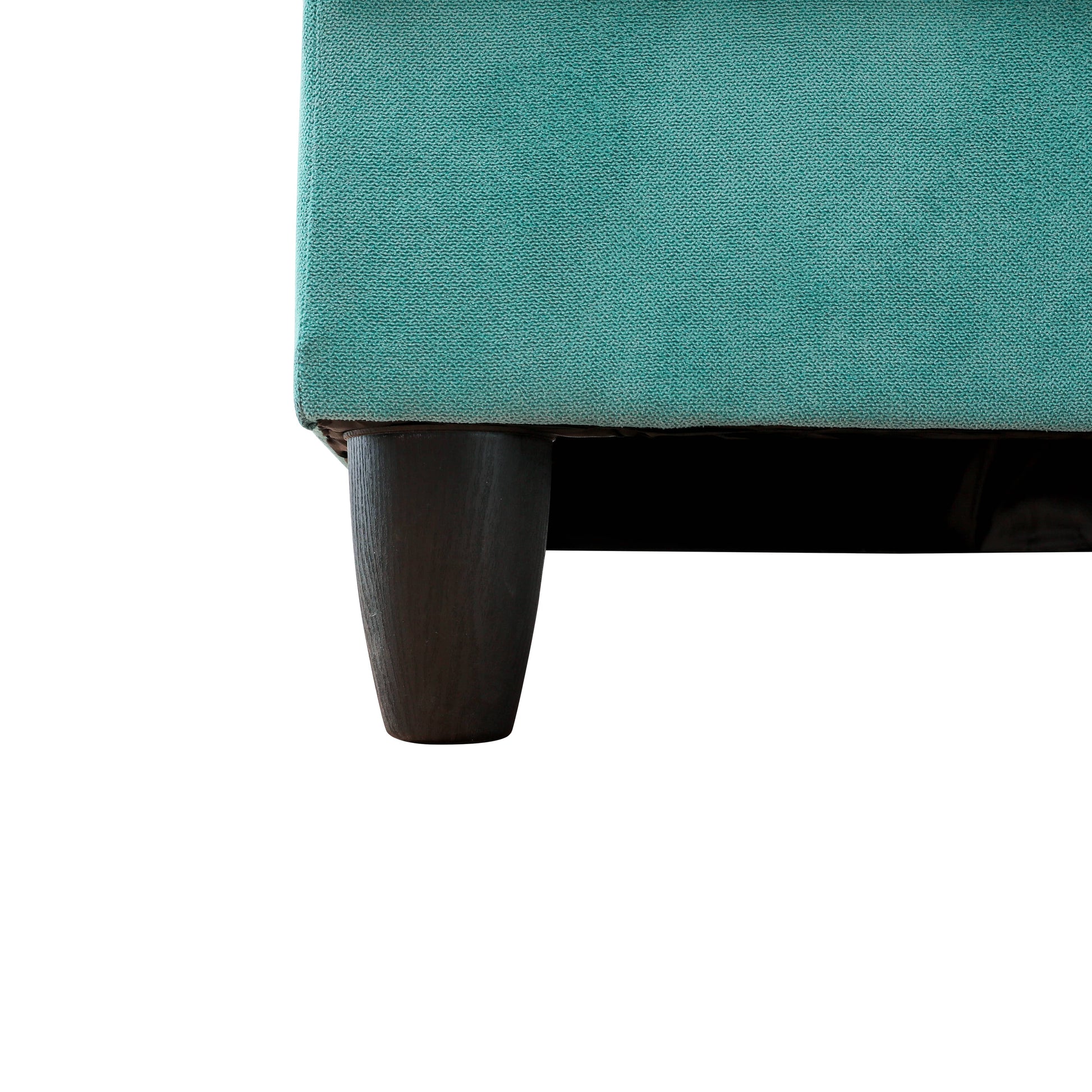 Closeup of teal textured fabric sofa with dark wooden leg