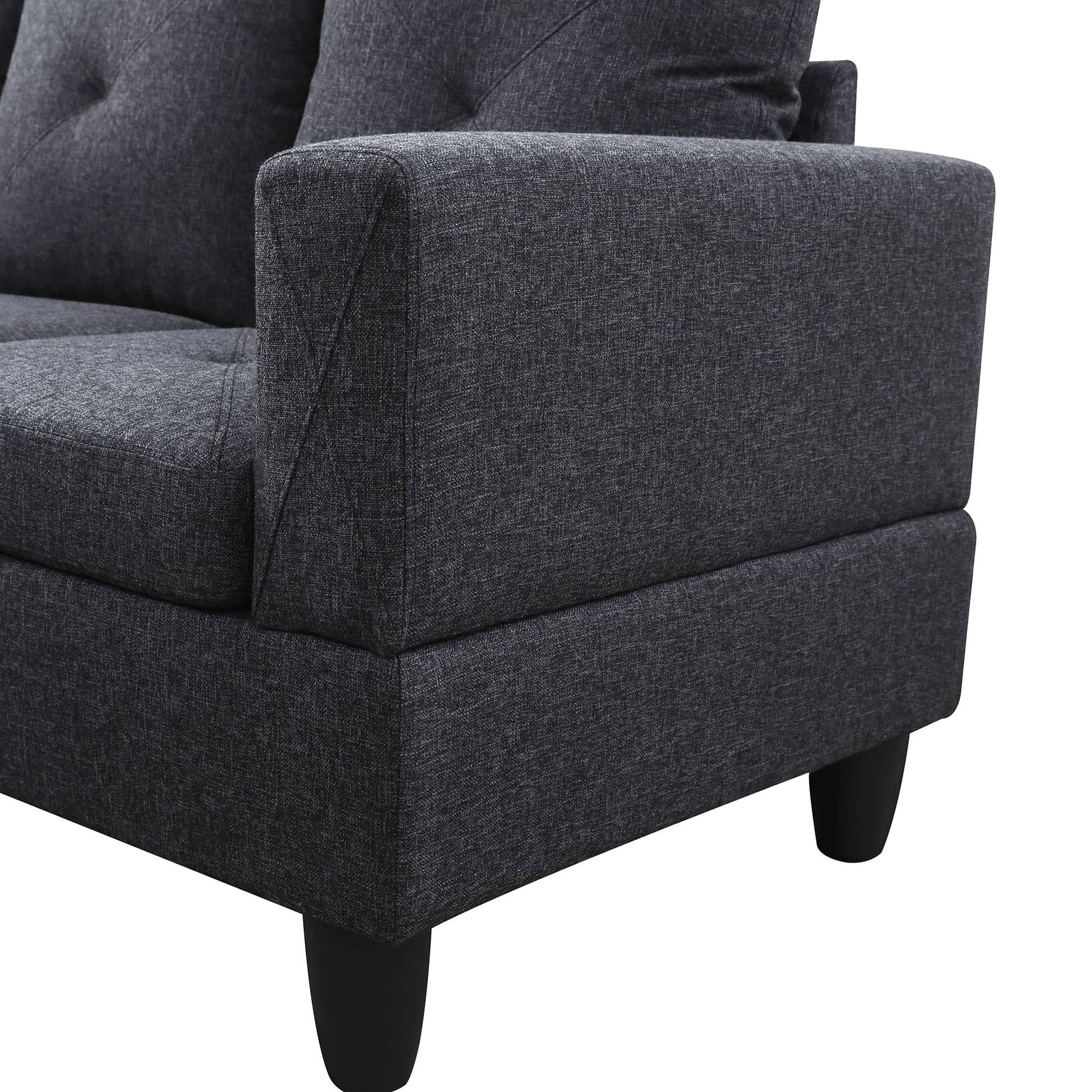 Dark grey upholstered sofa armrest with textured fabric and buttontufted back cushion