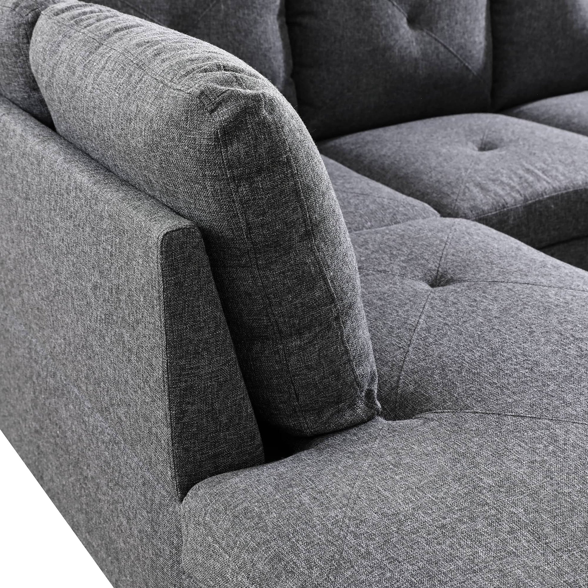 Closeup of grey fabric sectional sofa with tufted cushions