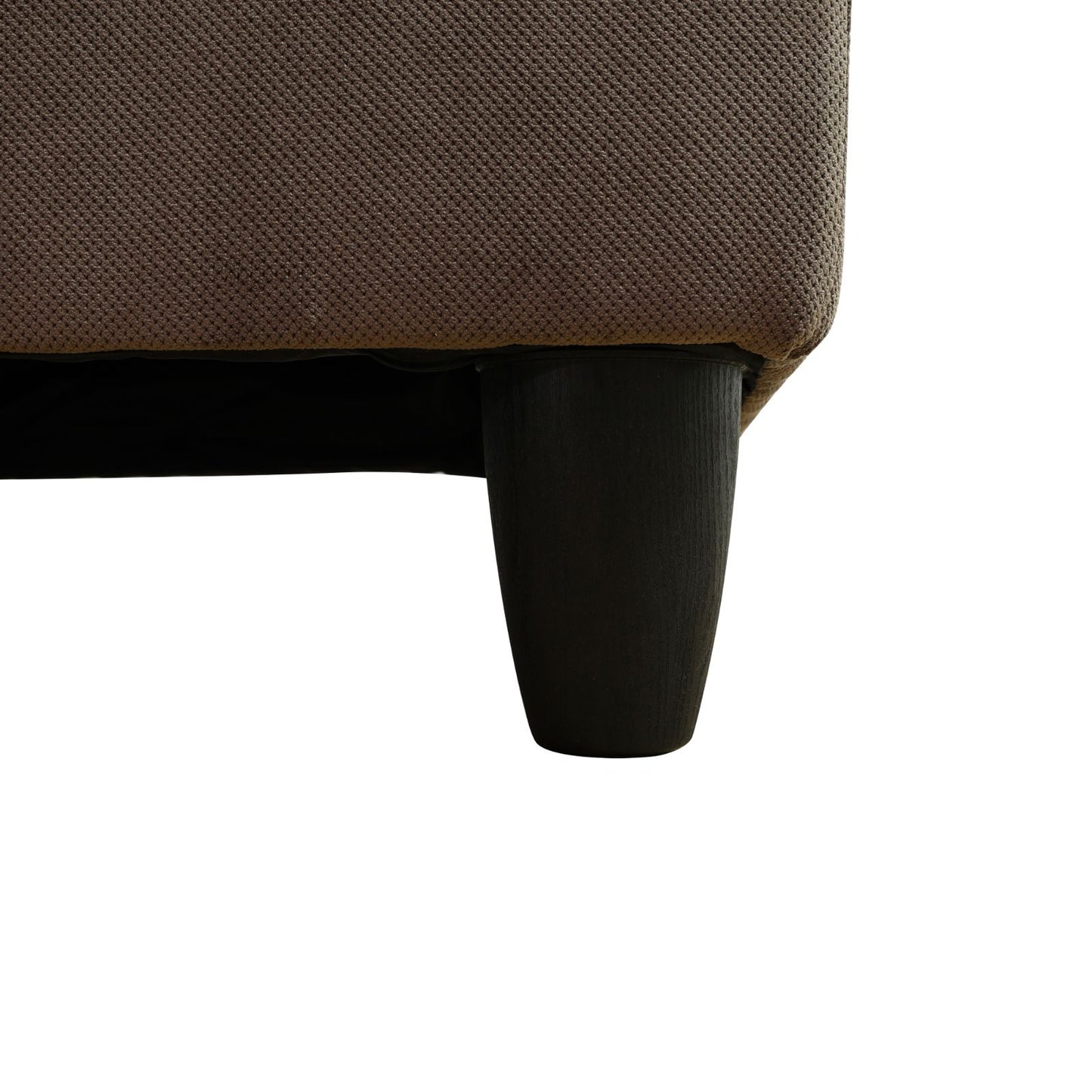 Brown textured fabric sofa corner with a dark wooden tapered leg