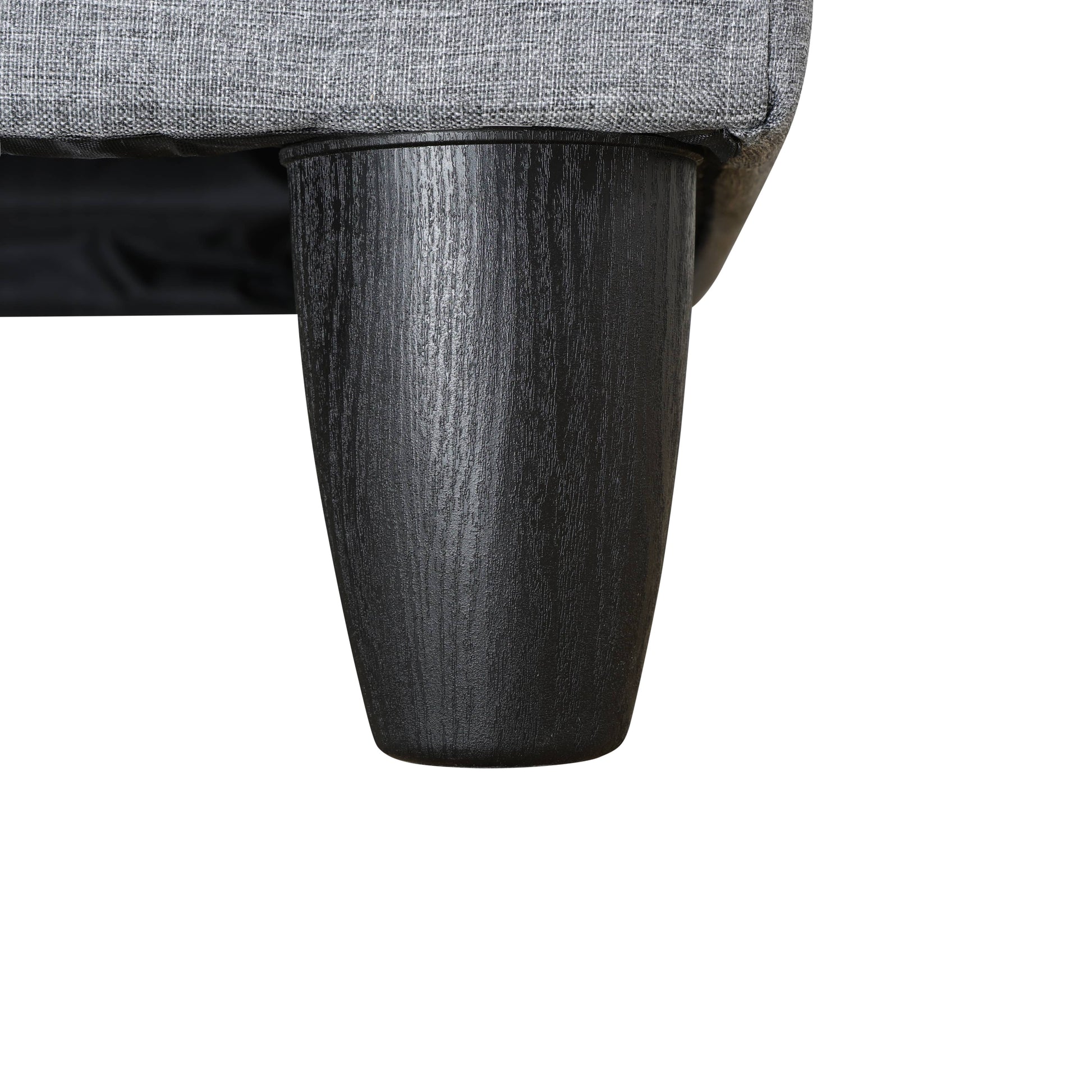 Textured gray fabric sofa detail with tapered black wood leg