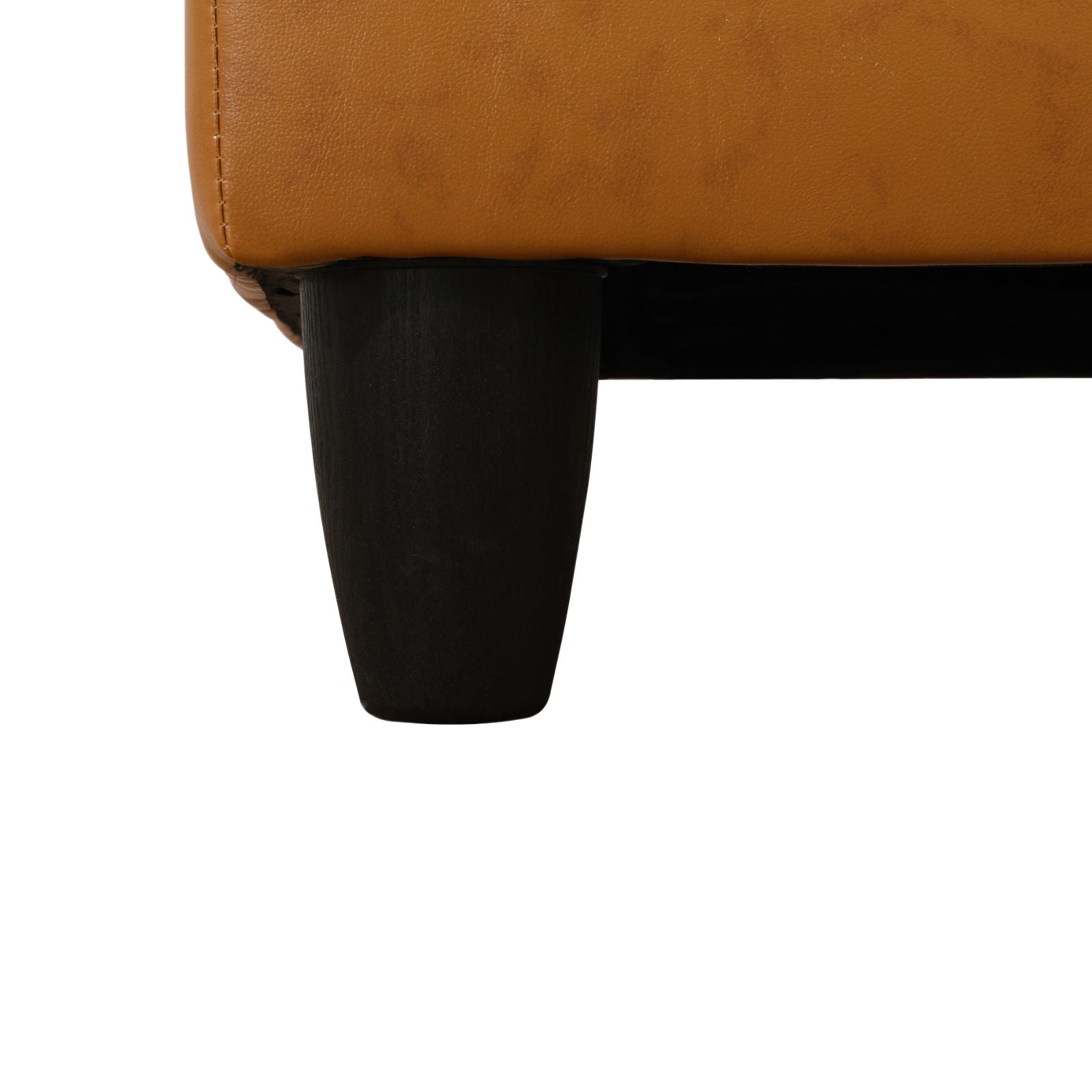 Tan leather sofa corner with dark wooden tapered legs