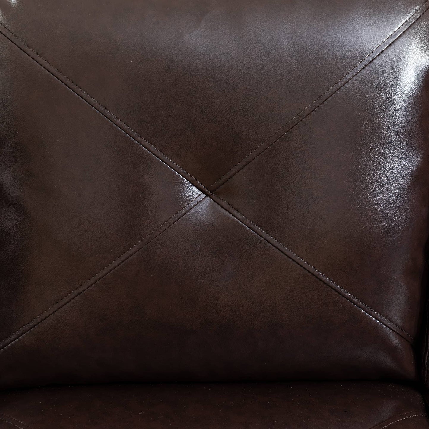 Closeup of stitched dark brown faux leather upholstery on a recliner