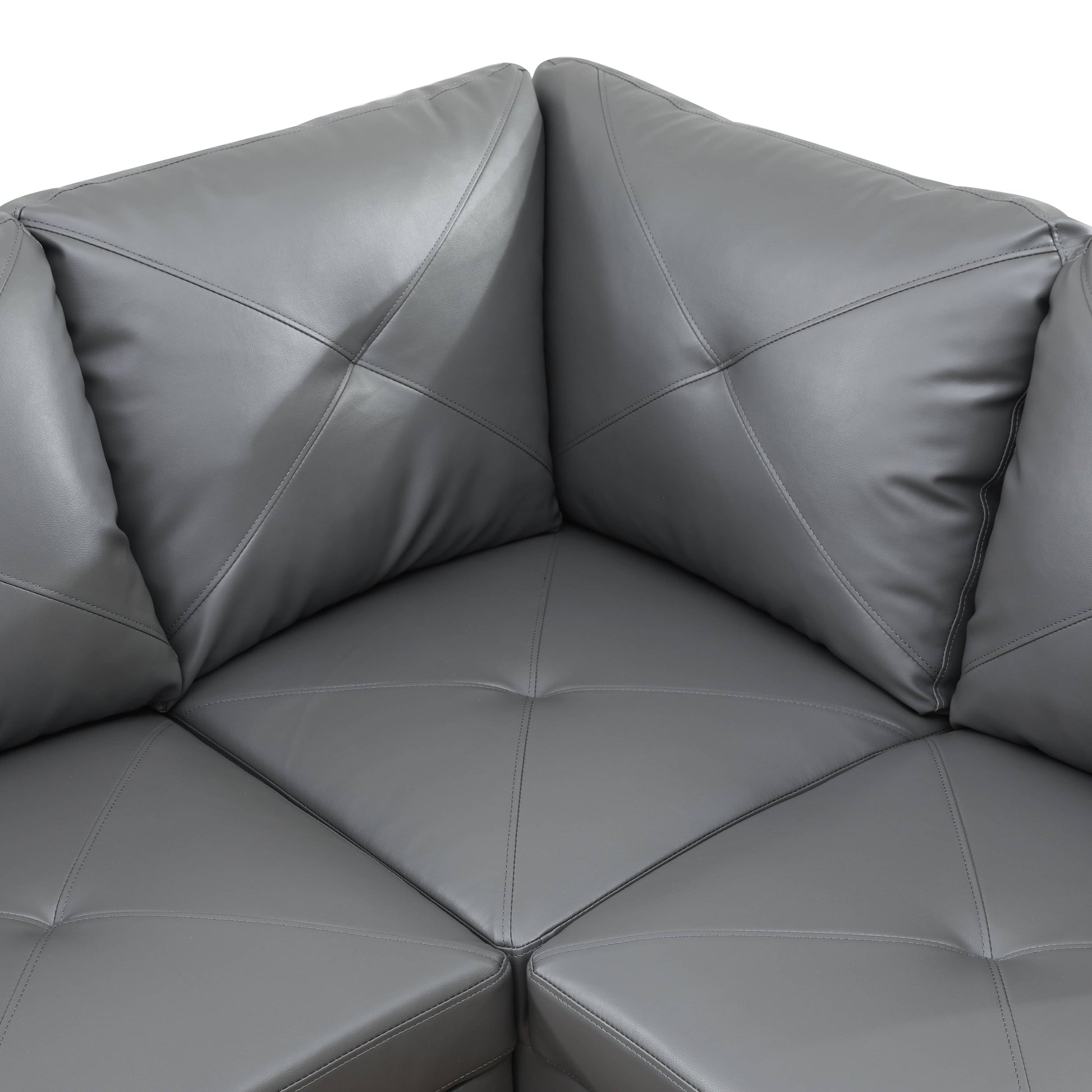 Closeup of gray faux leather sectional sofa with diamond stitching
