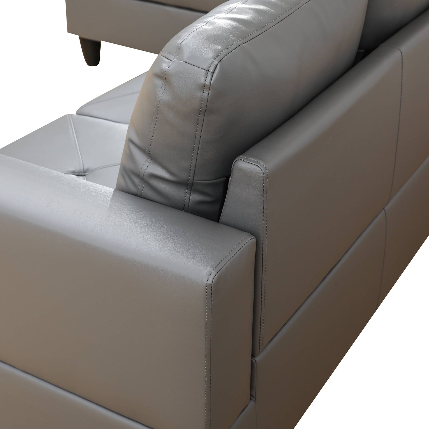 Closeup of a plush grey leather couch armrest with detailed stitching