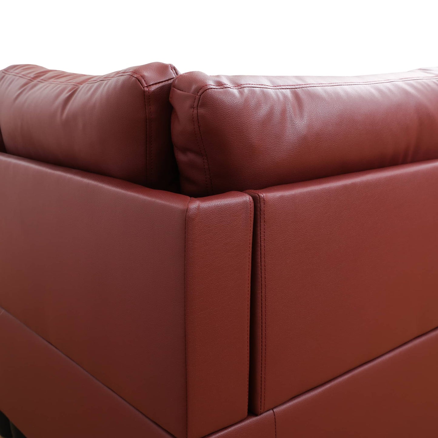 Closeup of rich red leather sofa corner detail with stitching